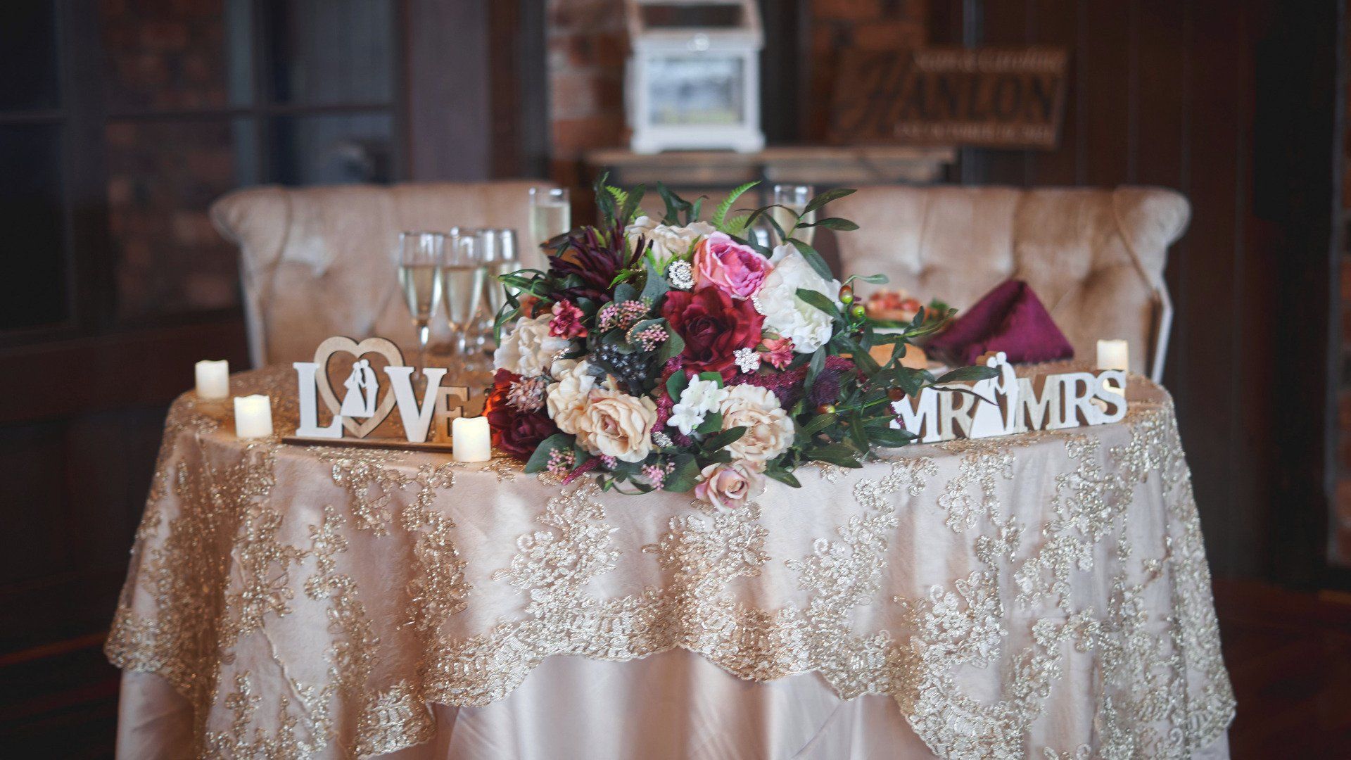 A table with flowers and candles on it and a sign that says `` mr. and mrs. ''