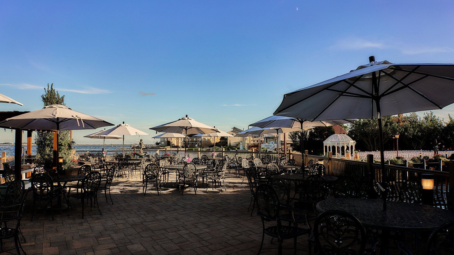 A row of tables and chairs under umbrellas on a beach