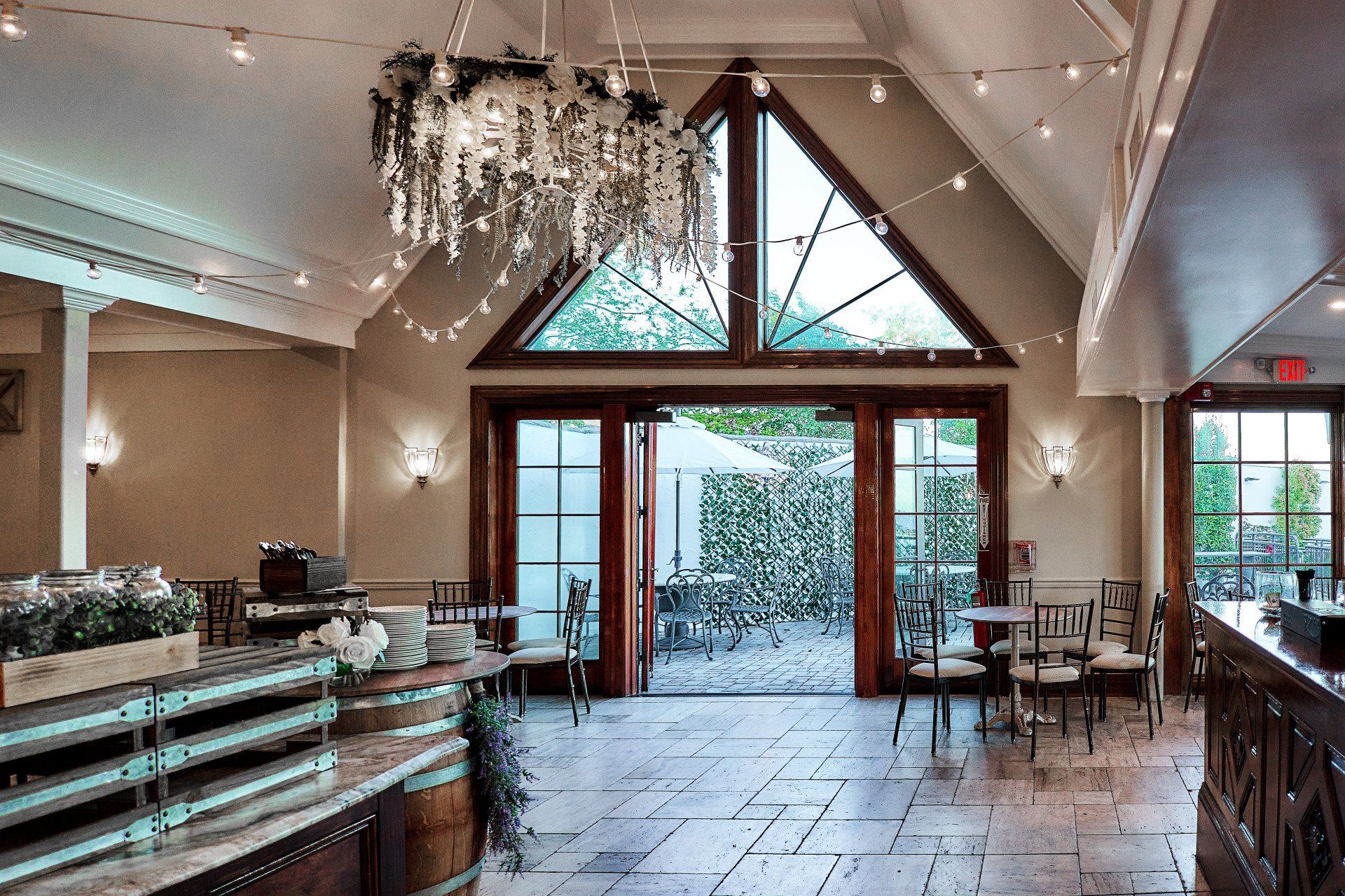 A large room with tables and chairs and a chandelier hanging from the ceiling.