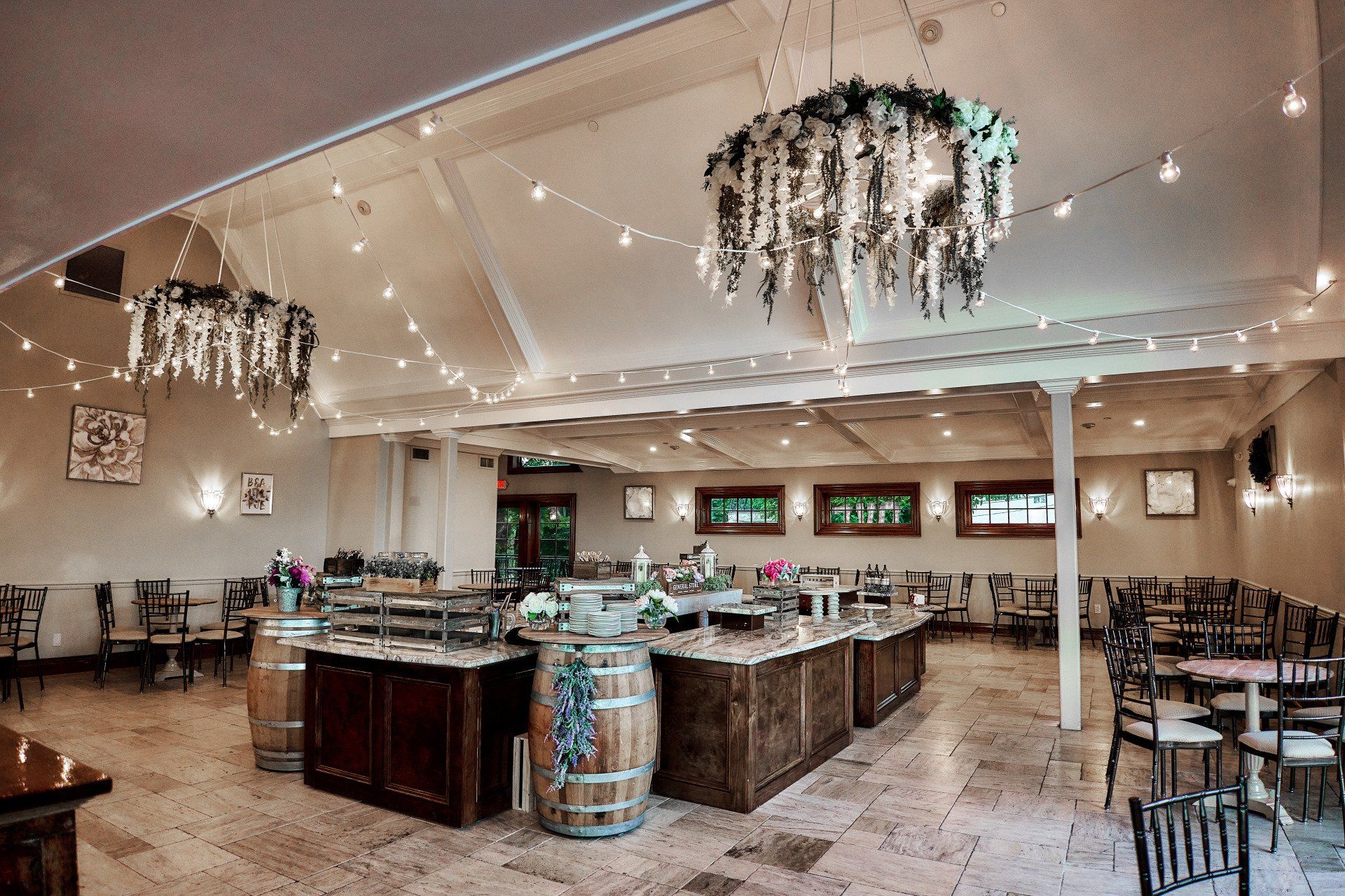 A large room with tables and chairs and a chandelier hanging from the ceiling.
