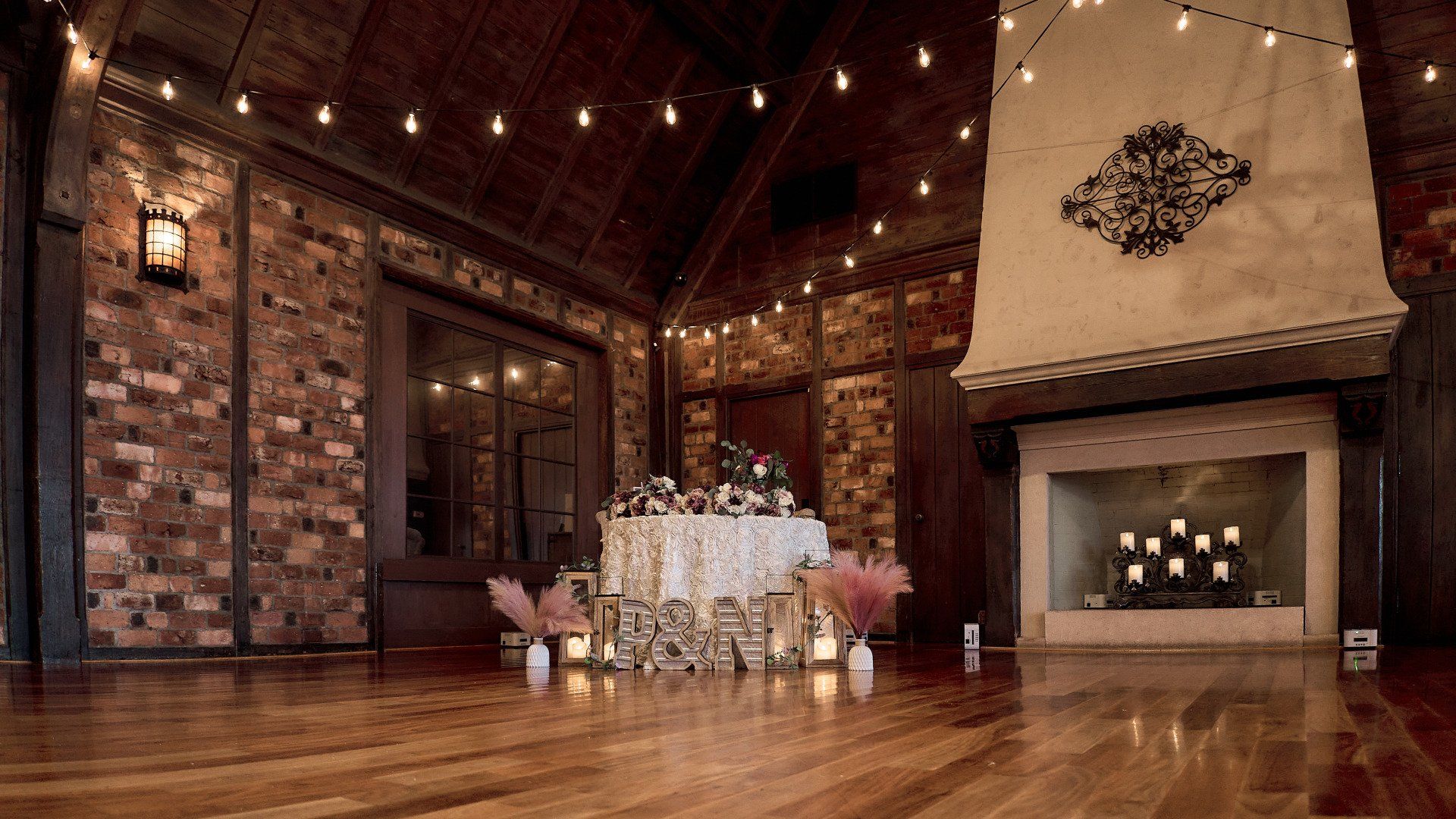 A large room with a fireplace and a table with candles on it.