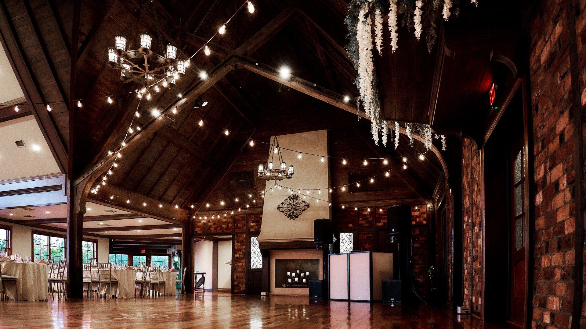 A large empty room with a dance floor and a fireplace.