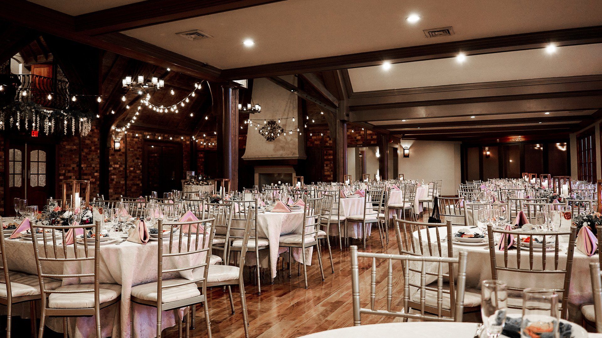 A large room with tables and chairs set up for a wedding reception.