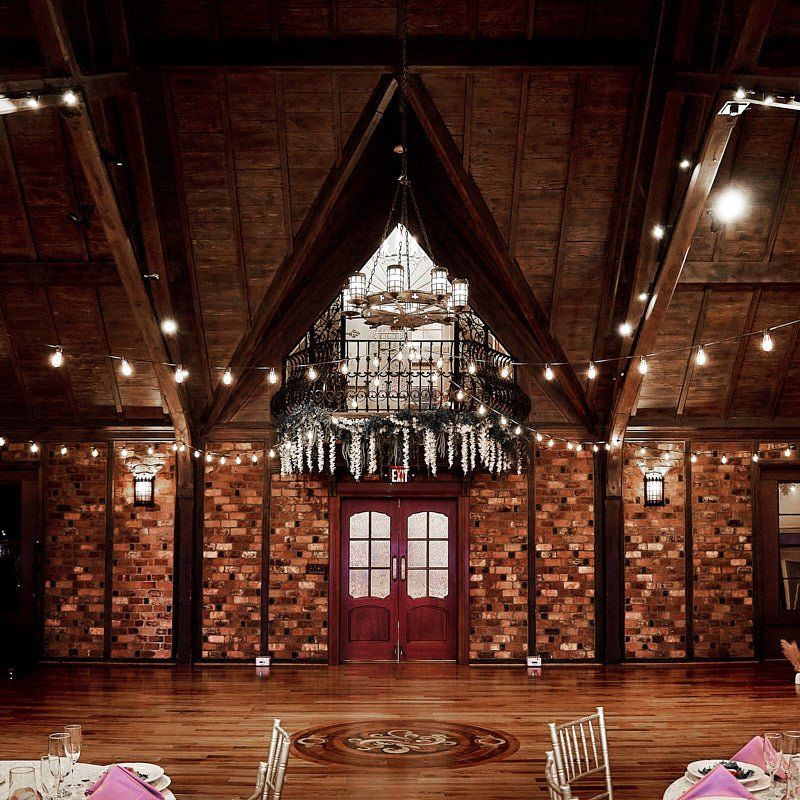 A large room with tables and chairs and a chandelier hanging from the ceiling.