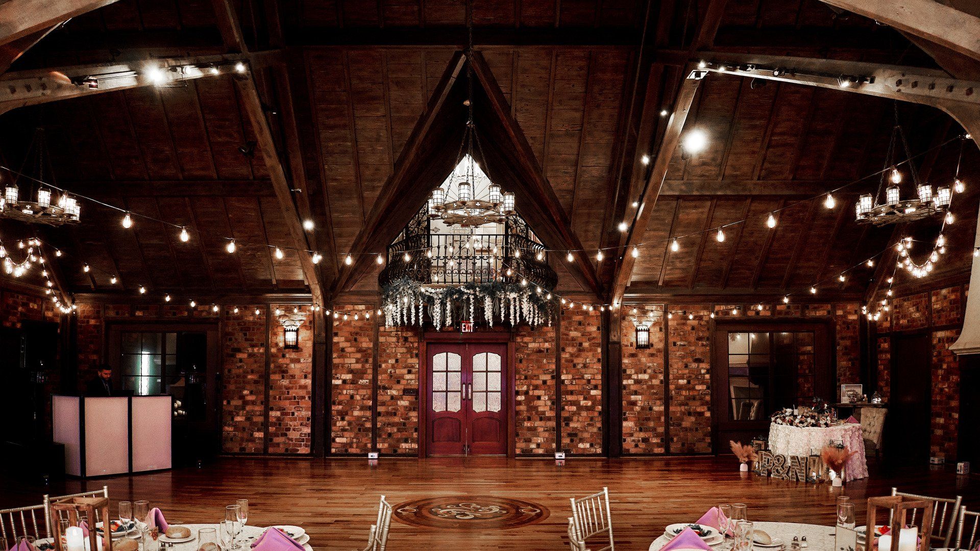 A large room with tables and chairs and a chandelier hanging from the ceiling.