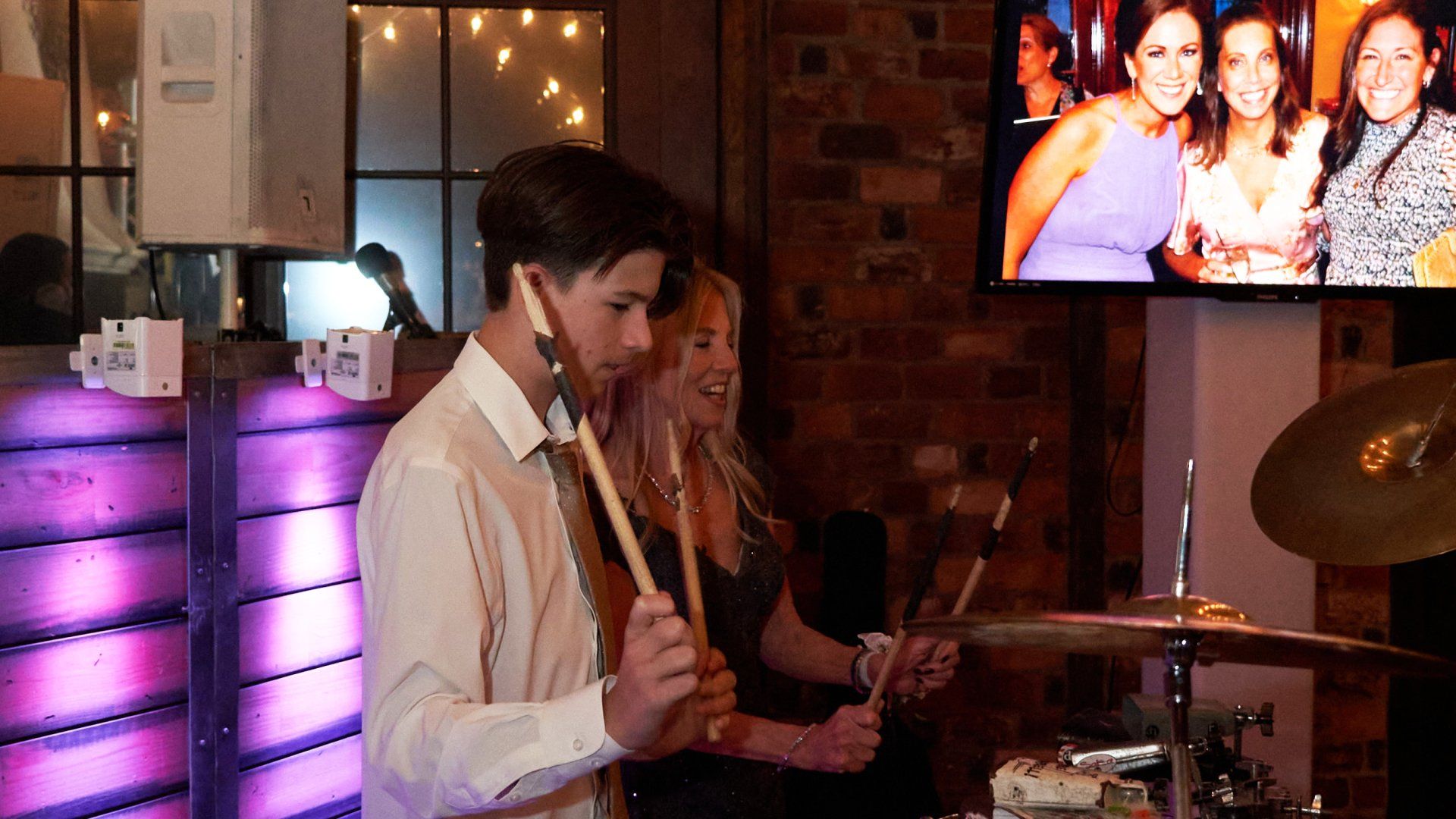 A man is playing drums in front of a group of people.