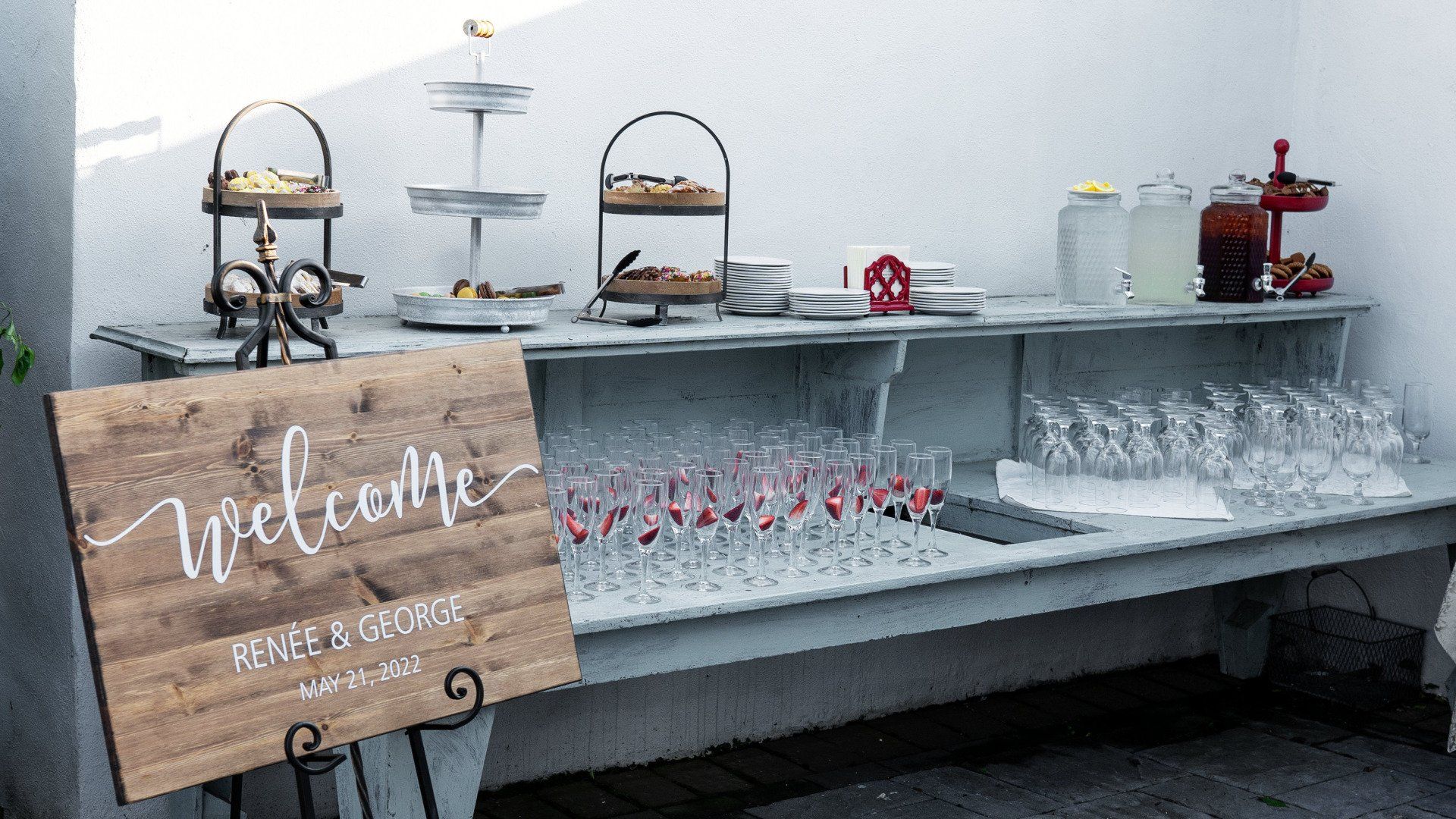 A wooden welcome sign is sitting on a table next to a buffet.