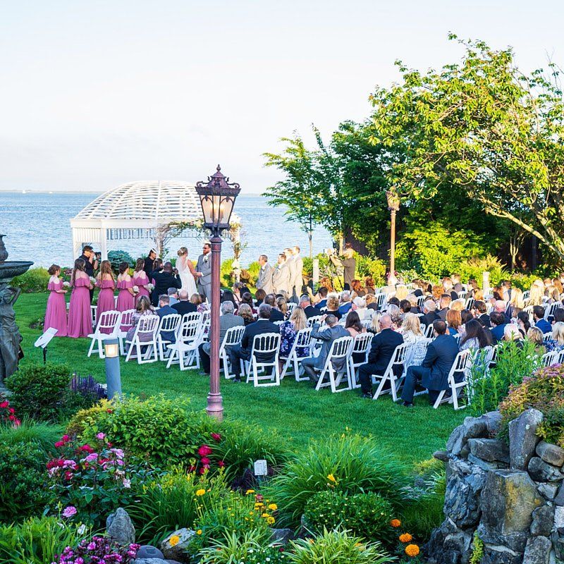 A wedding ceremony is taking place in front of the ocean
