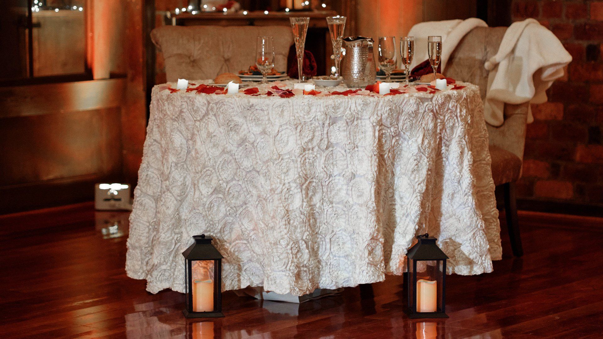A table with a white tablecloth and candles on it