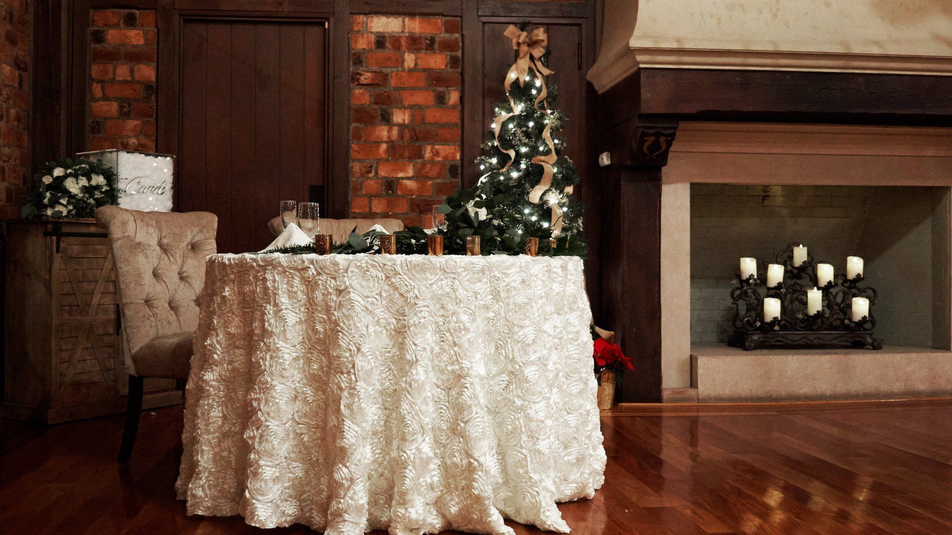 A table with a white tablecloth and a christmas tree in the background.