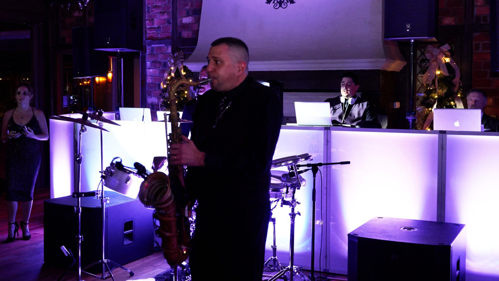 A man is playing a saxophone in a dark room.