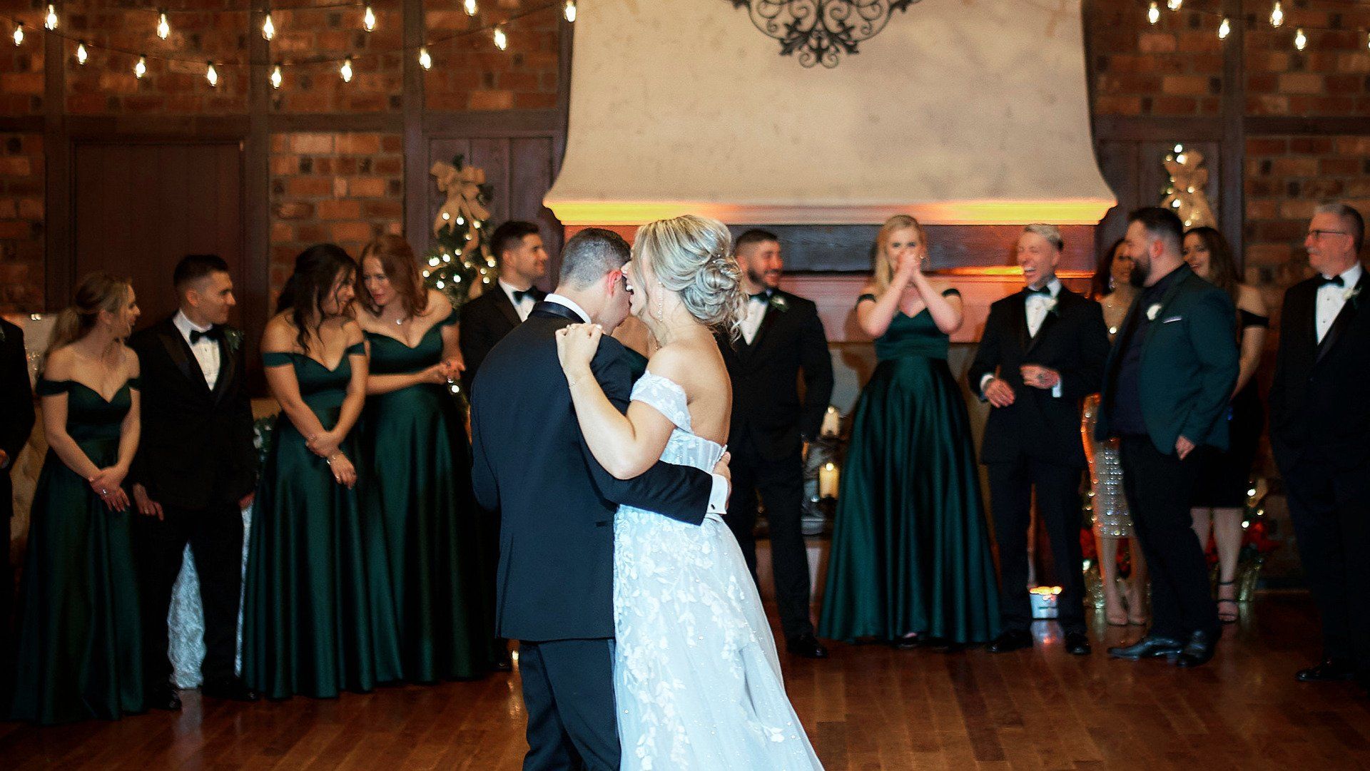 A bride and groom are dancing in front of their wedding party.
