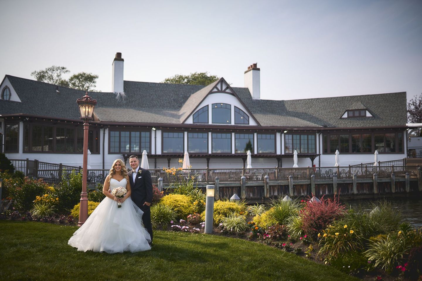 a bride and groom are standing in front of a large house