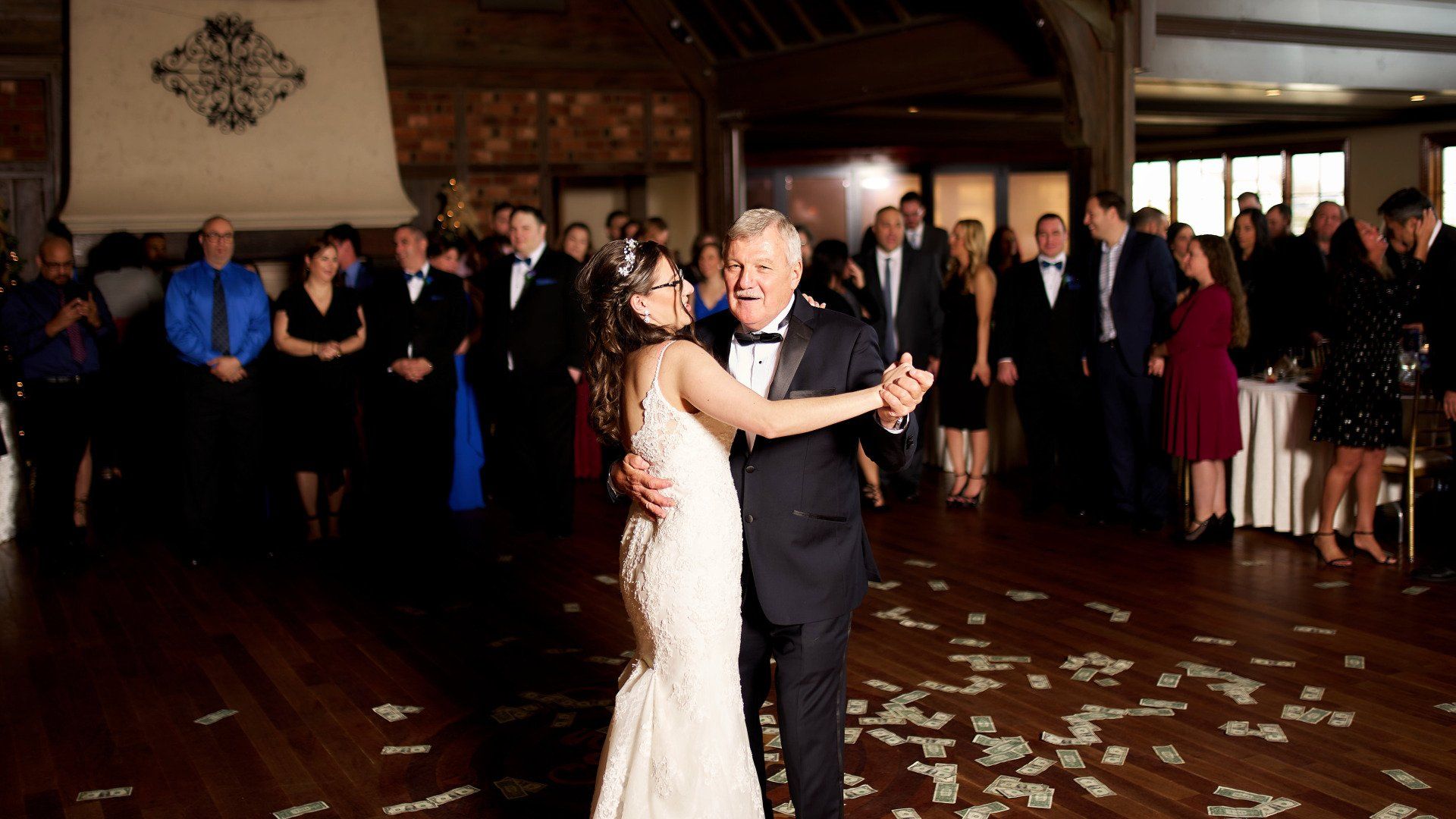 A bride and her father are dancing at a wedding reception.