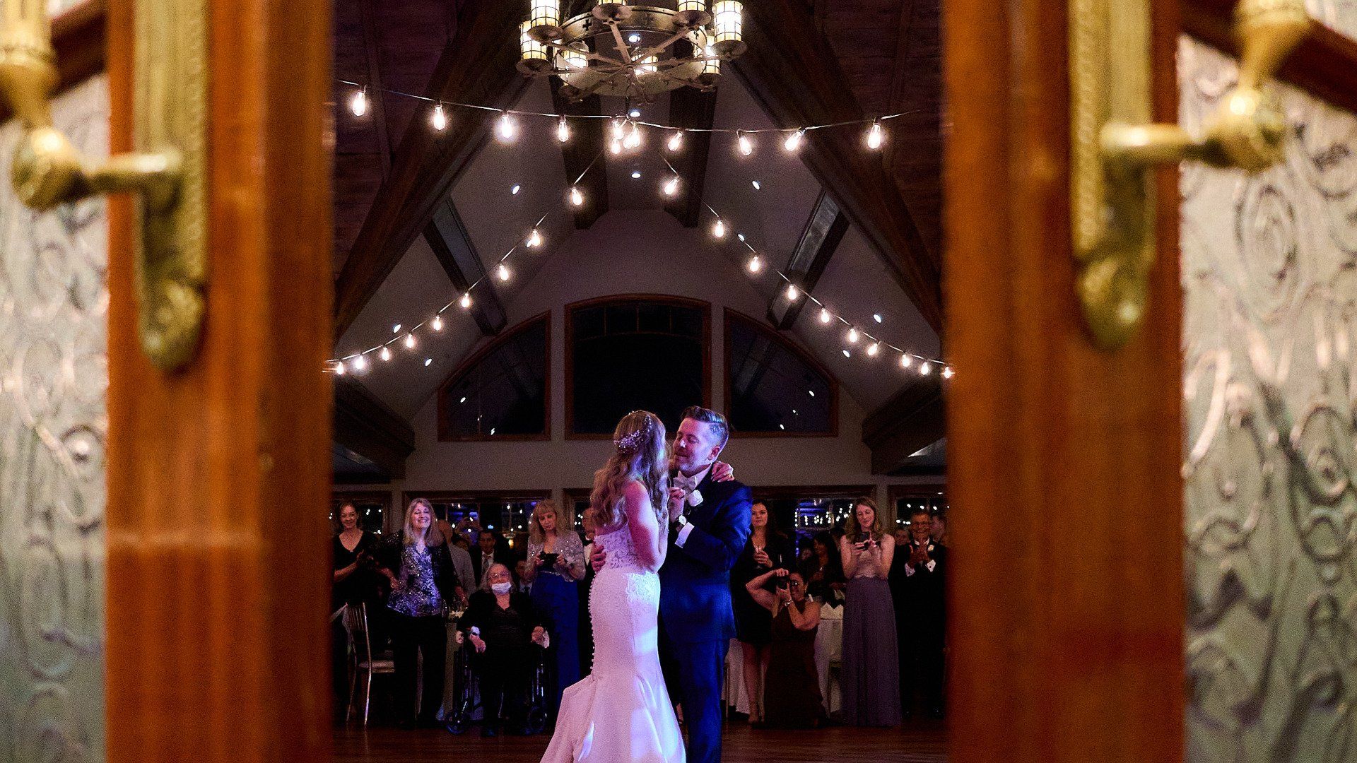 A bride and groom are dancing their first dance at their wedding reception.