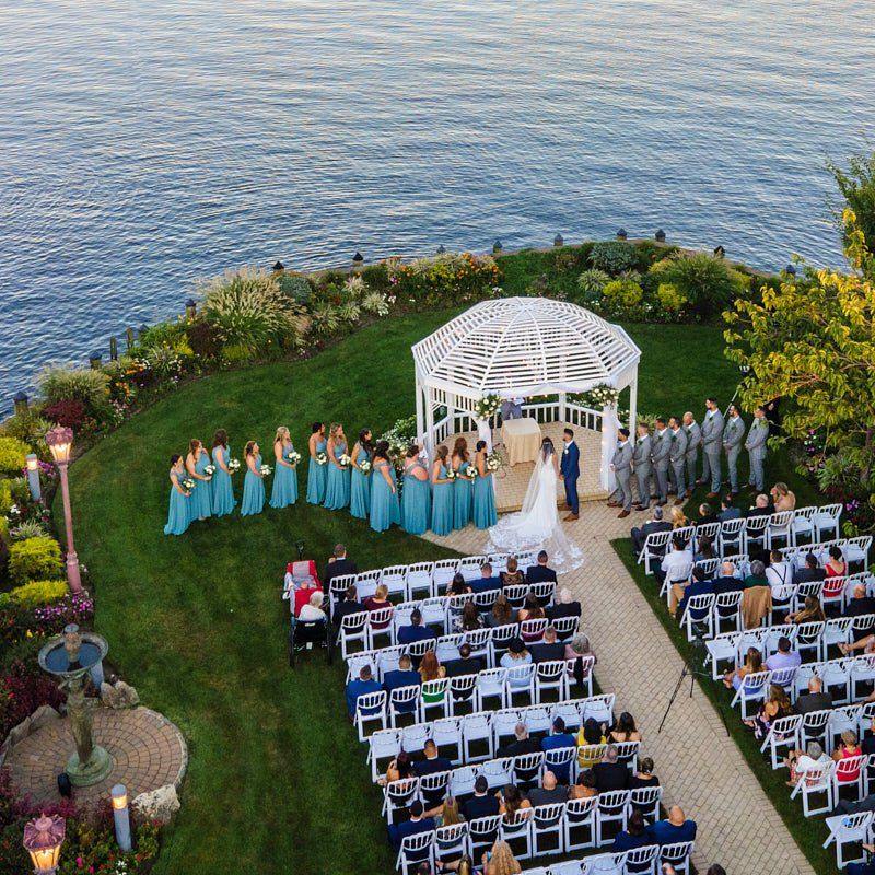 An aerial view of a wedding ceremony in front of the ocean