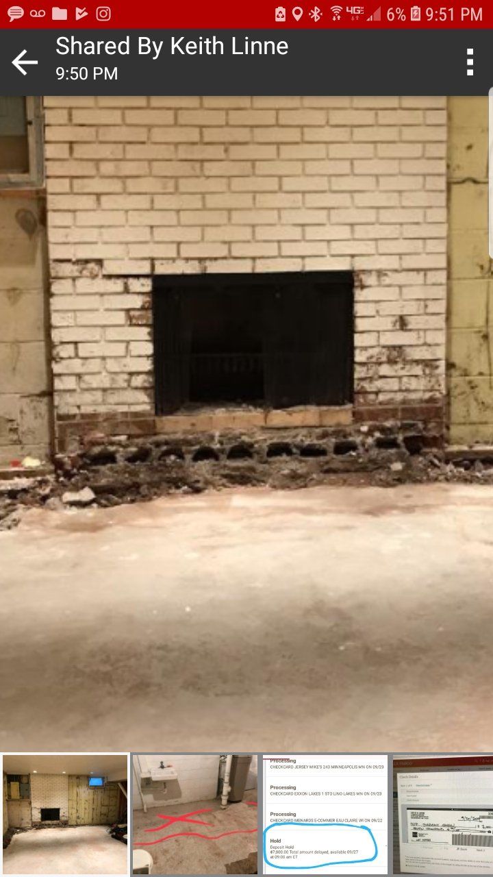 Fireplace with brick surround, black opening, unfinished floor.