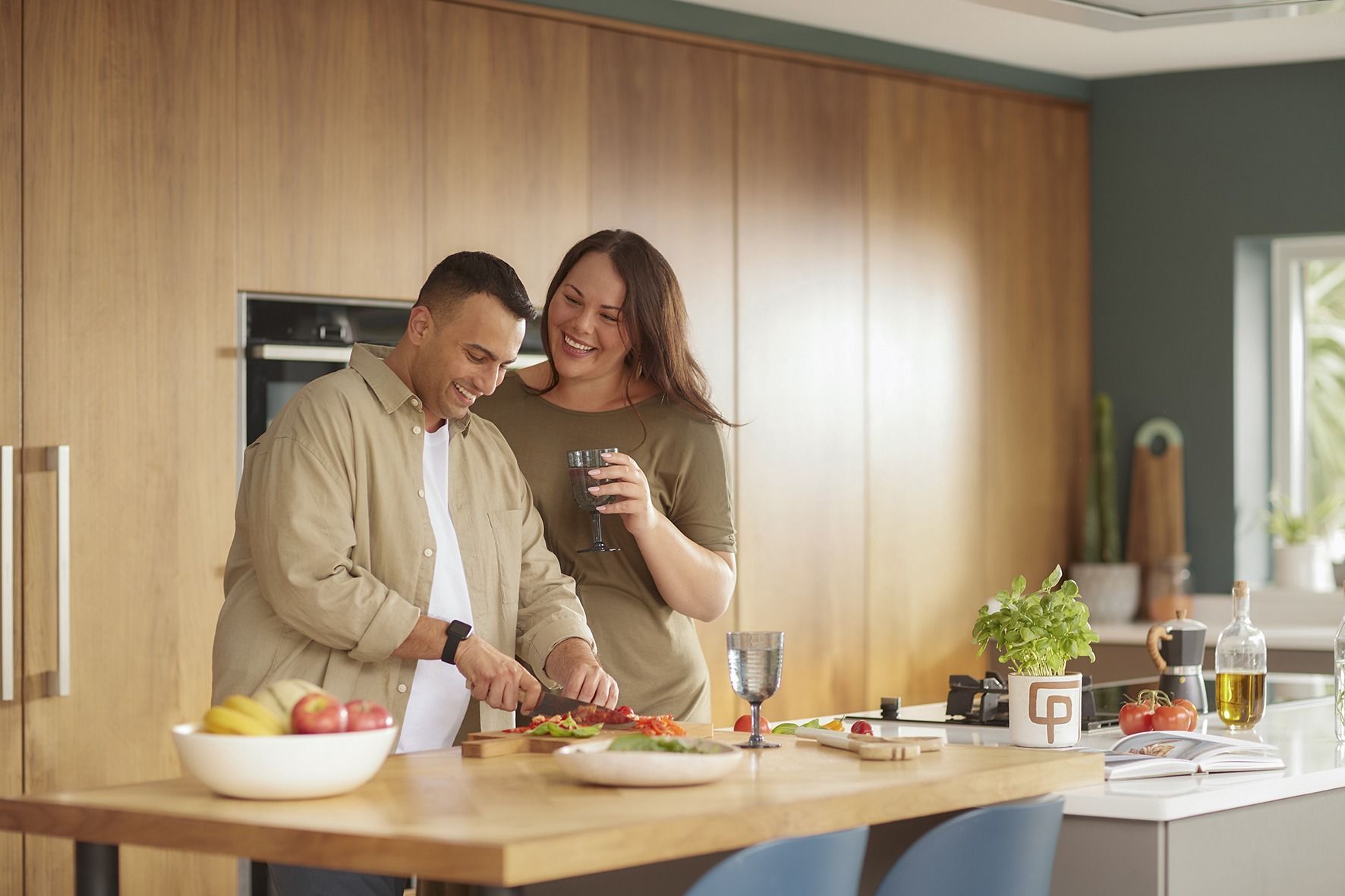 A man and a woman are preparing food in a kitchen.