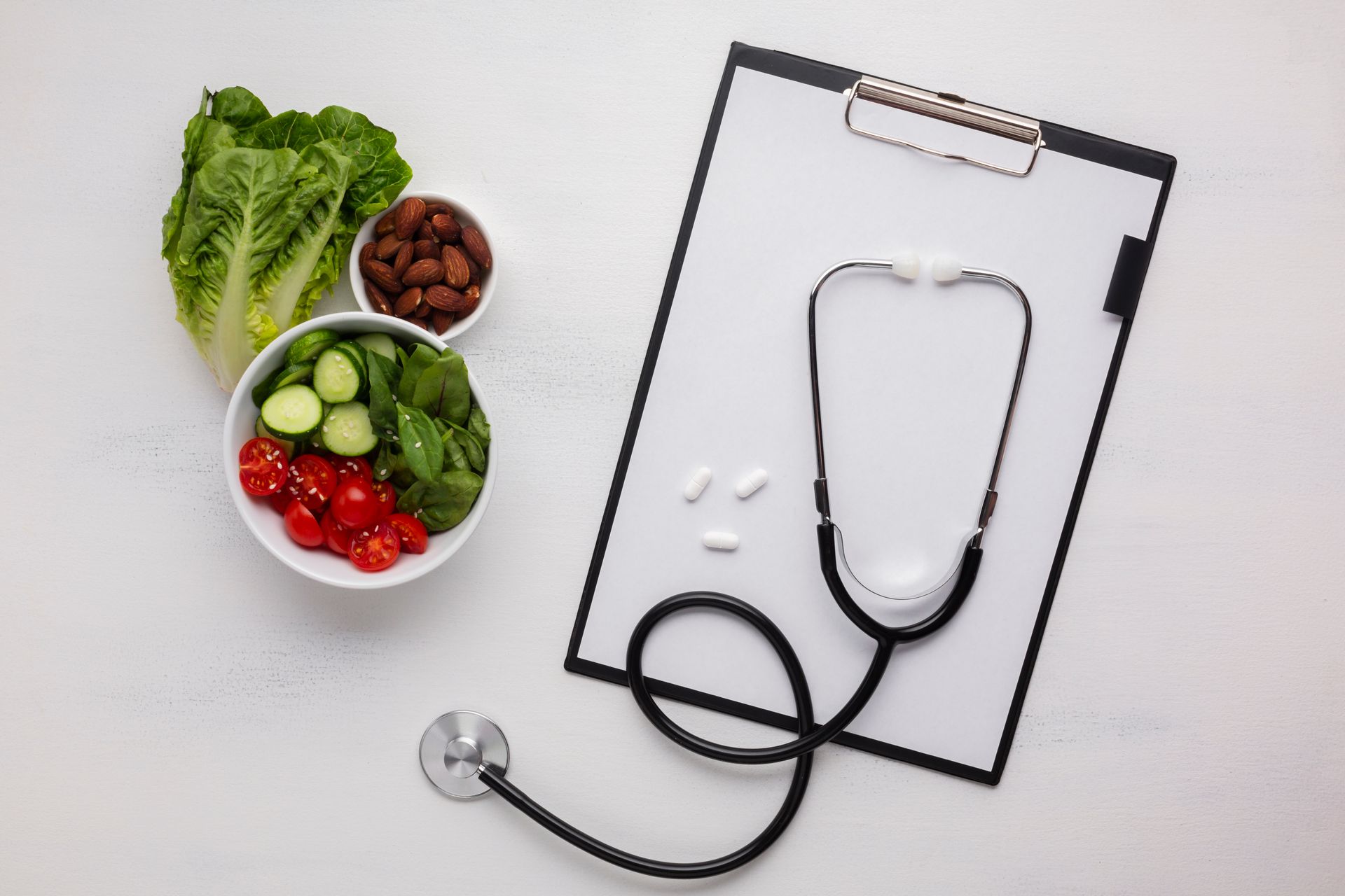 a clipboard with a stethoscope and a bowl of vegetables on it