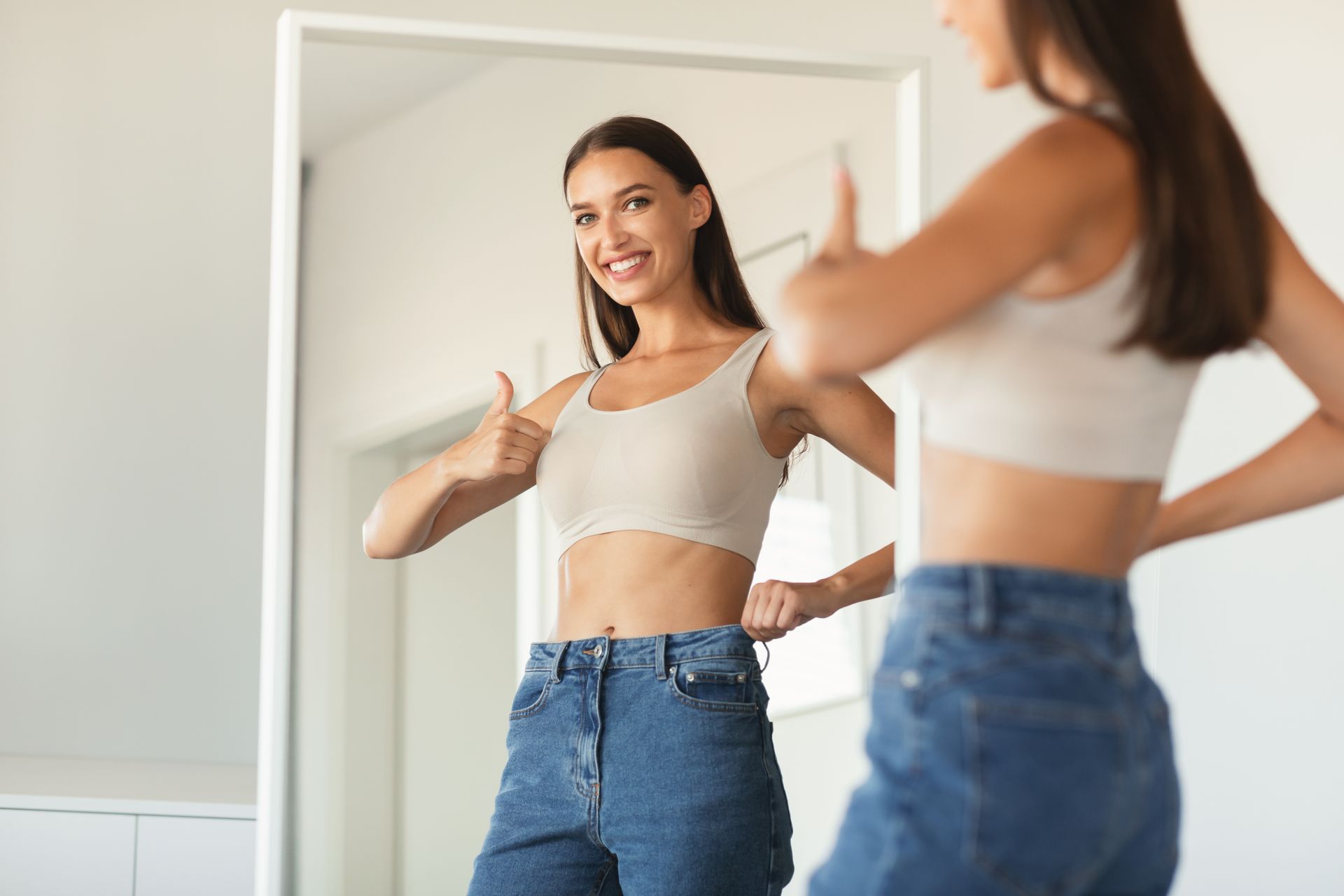 a woman giving a thumbs up in front of a mirror