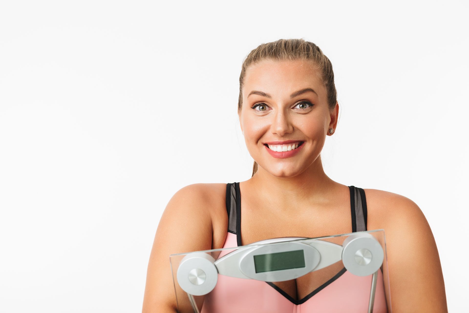 smiling woman with excess weight holding scales hands 