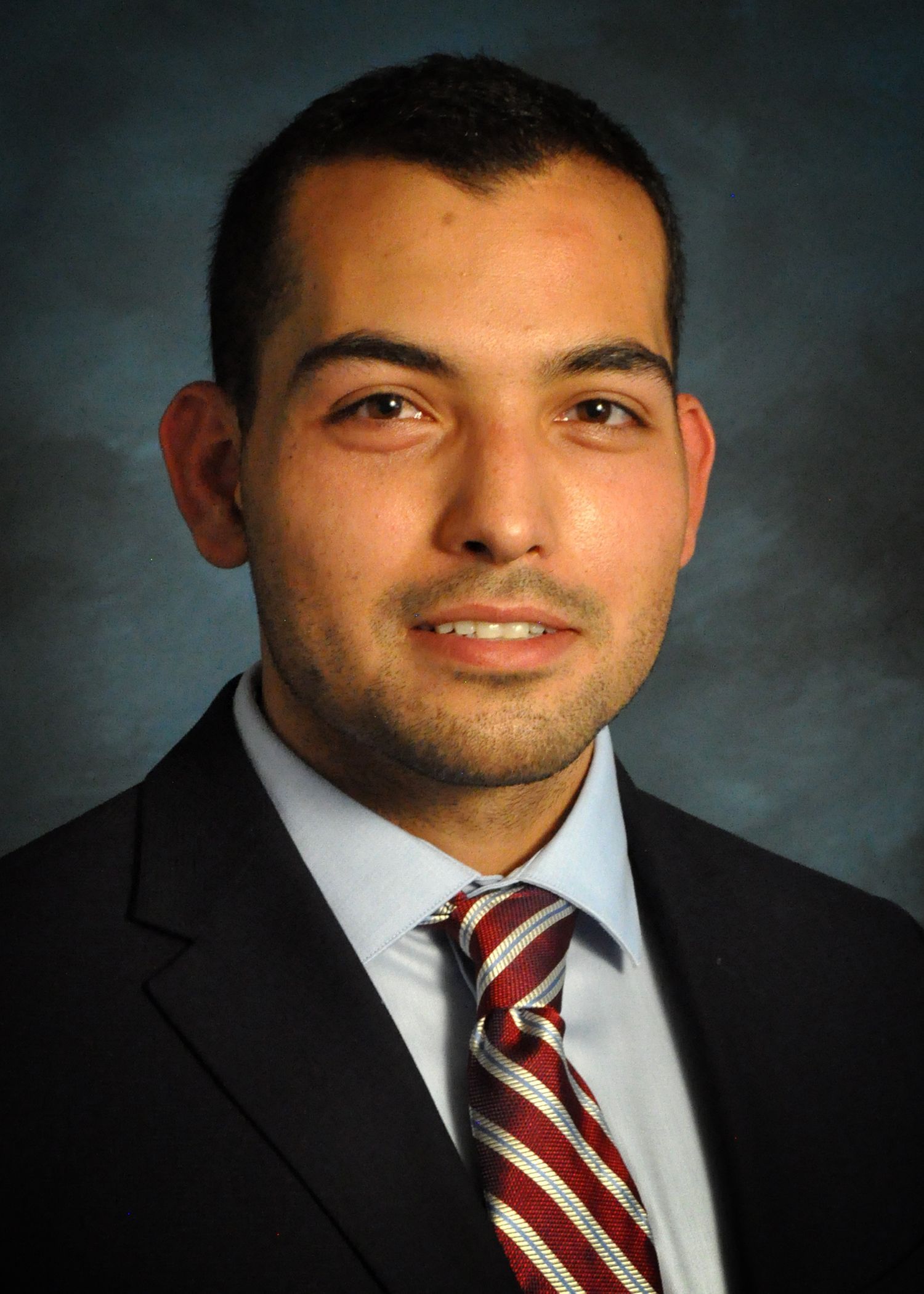 A man in a suit and tie is smiling for the camera