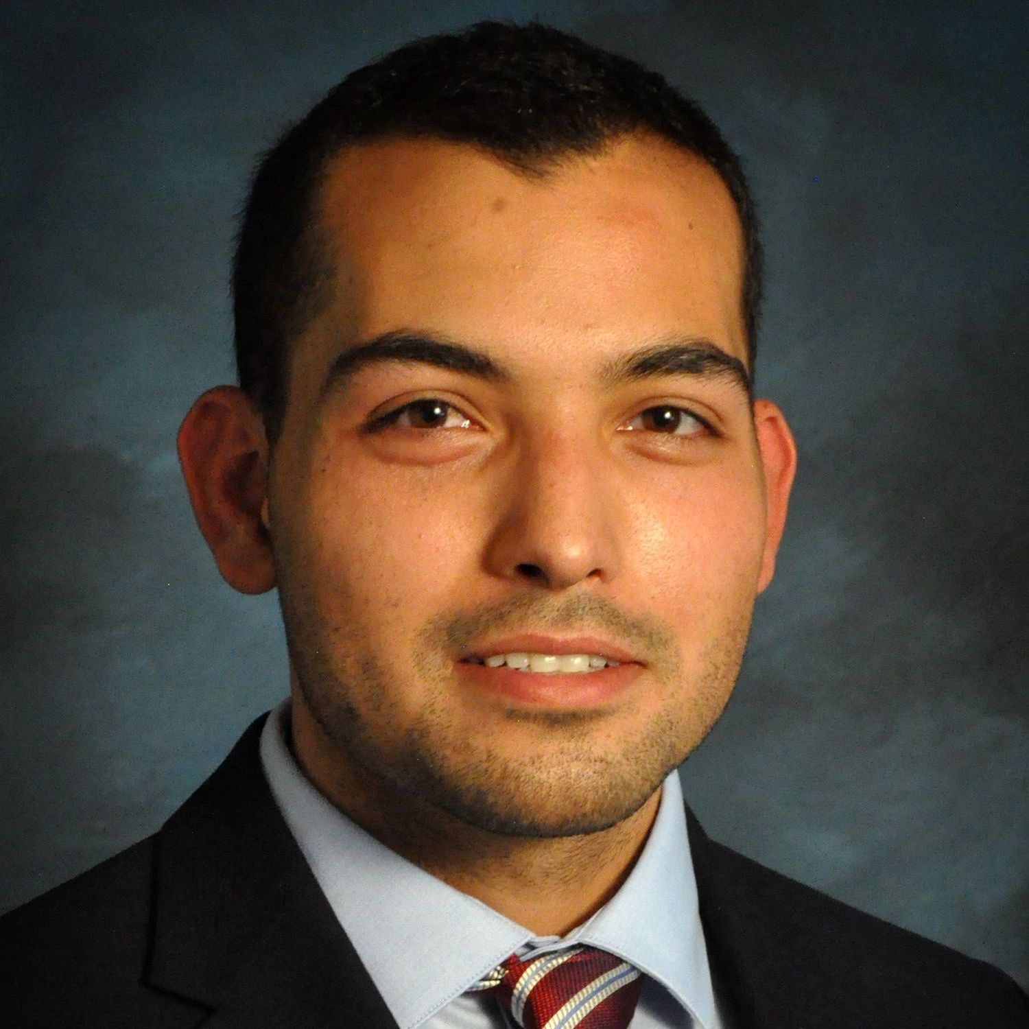 A man in a suit and tie is smiling for the camera