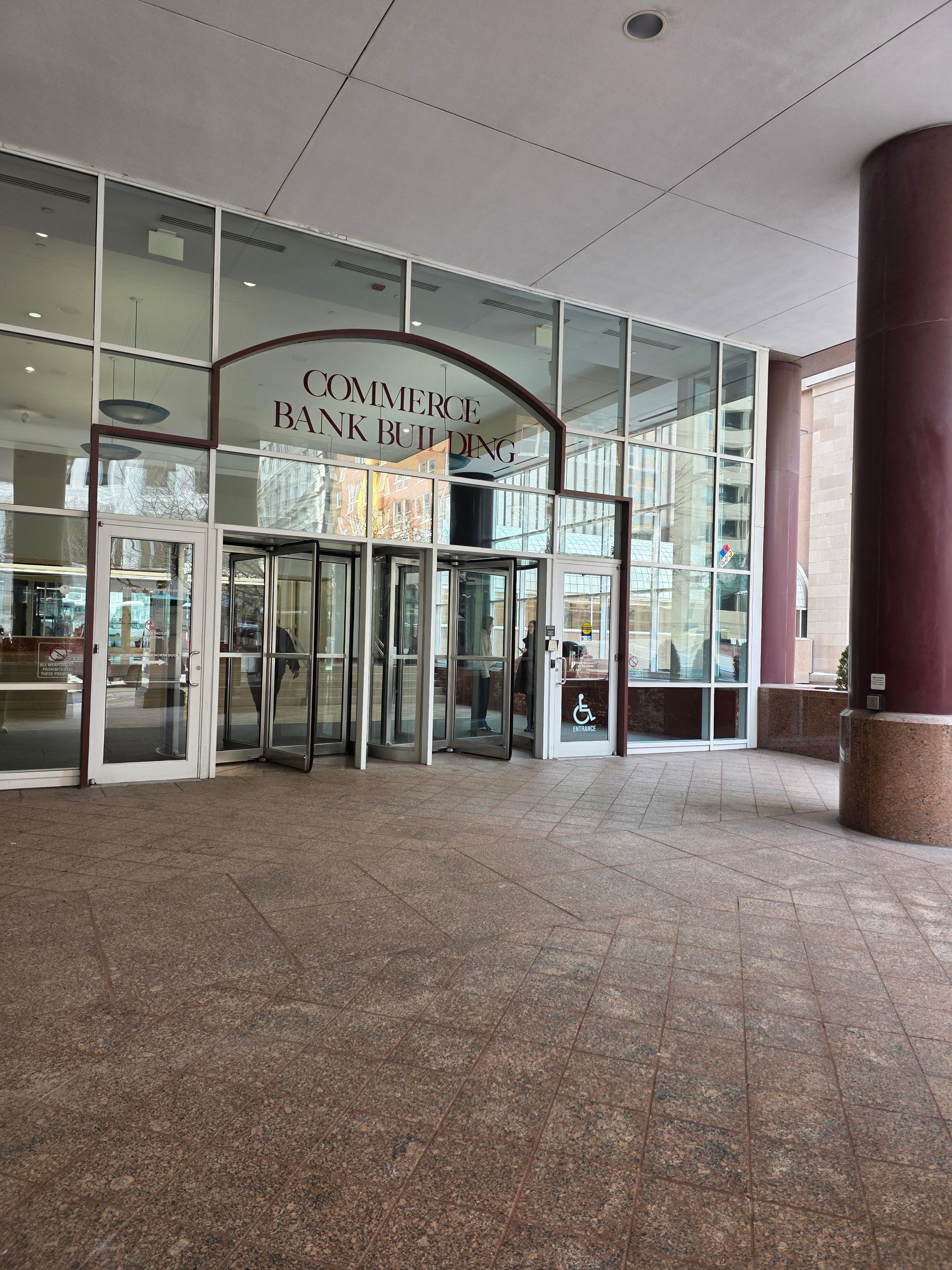 Entrance to Commerce Bank building with revolving doors and glass windows.