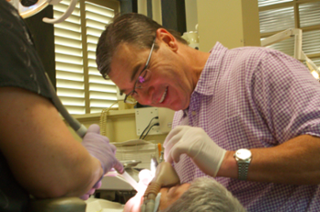 Dr. Thomas Anderson smiling while helping a patient
