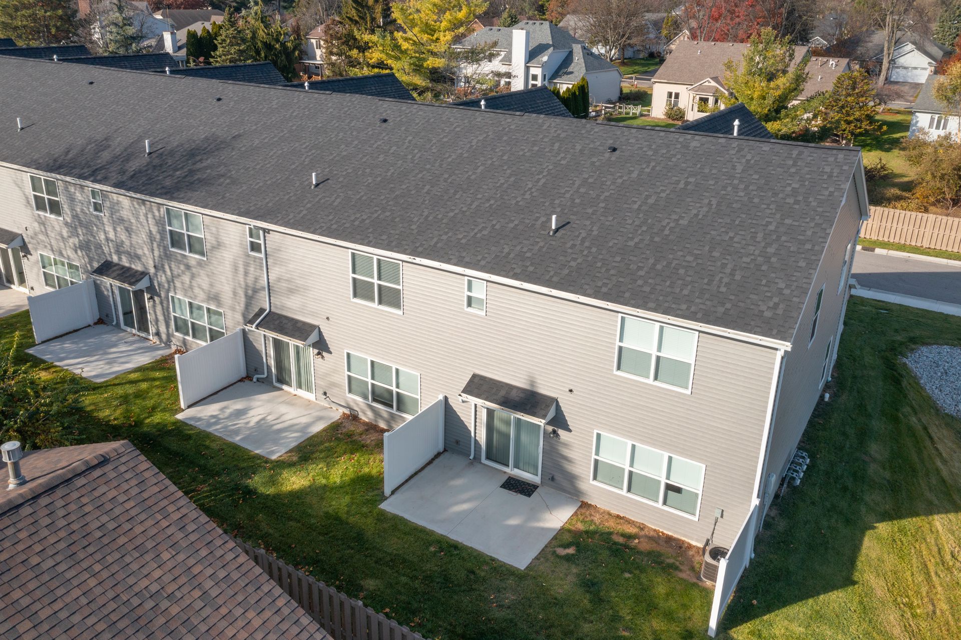 Photo of a few units, seen from behind with them having small privacy fences but a shared common space