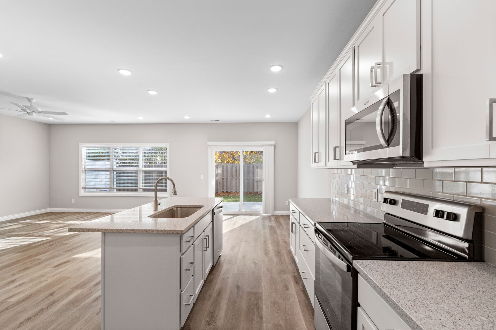 Photo of a kitchen showing the living room area in the background