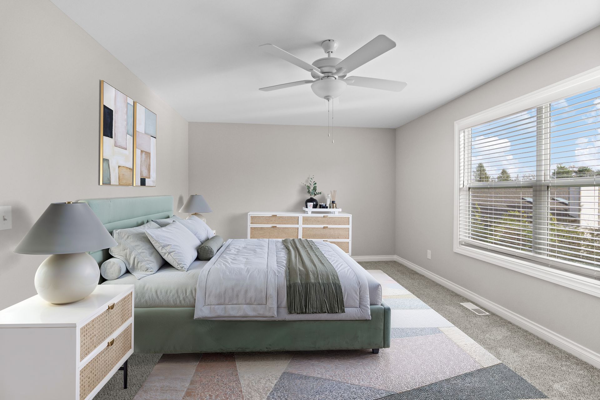 Photo of a bed in a bedroom with plenty of walking space and a wide window