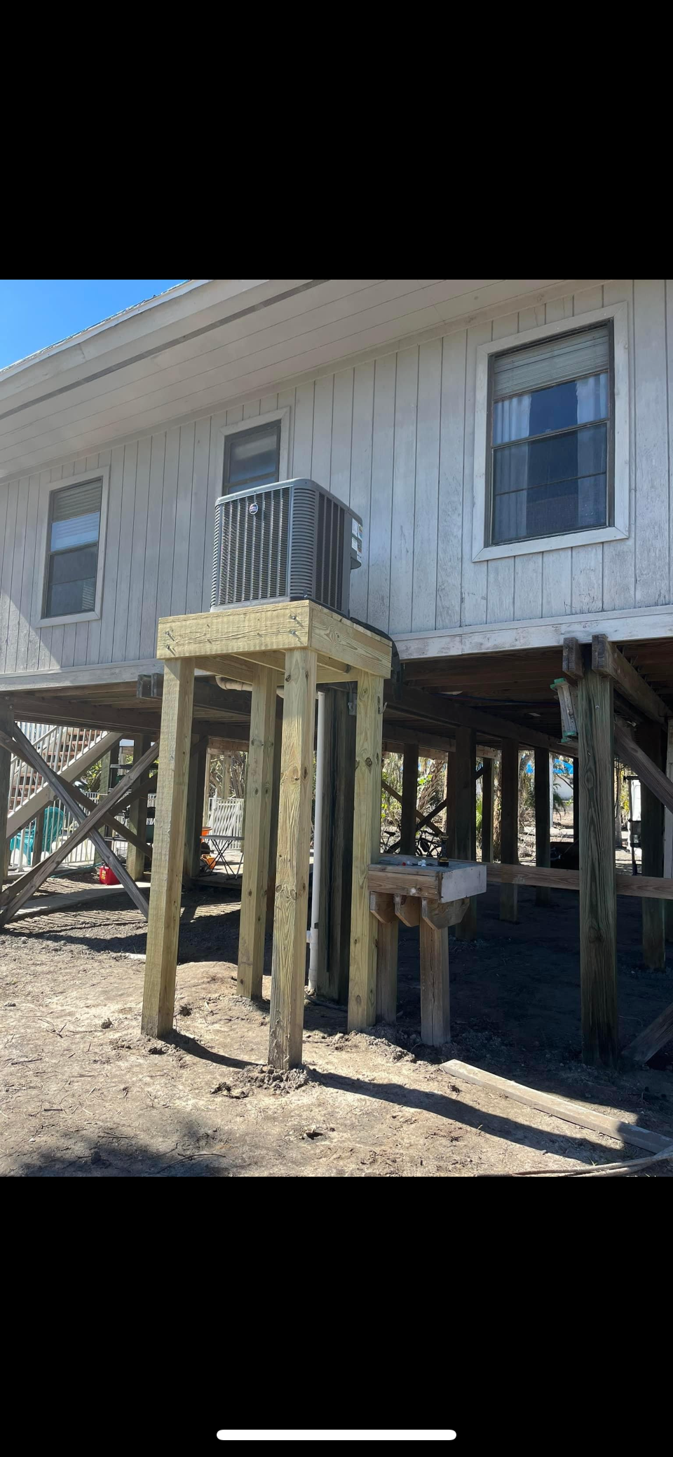 A house on stilts with a balcony on top of it.
