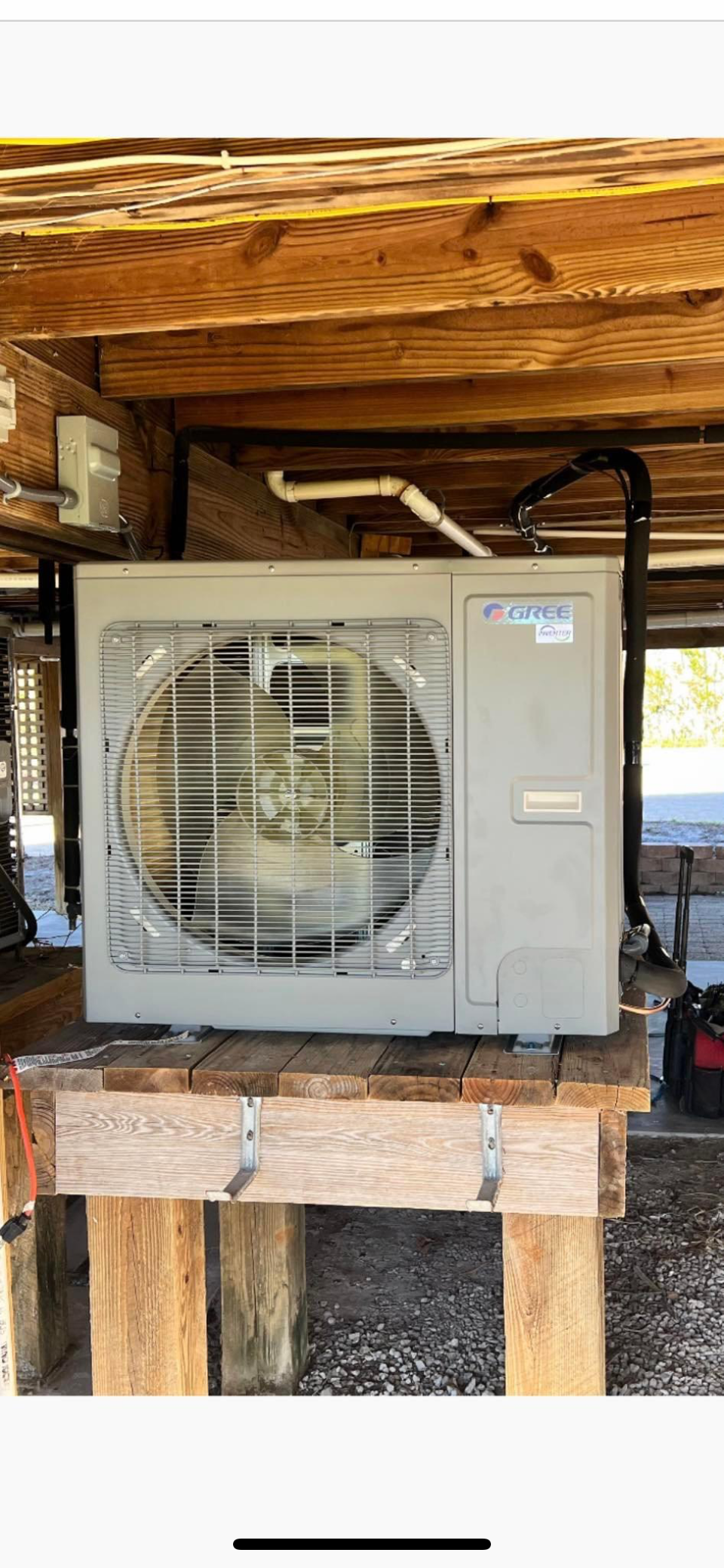 A white air conditioner is sitting on top of a wooden table.