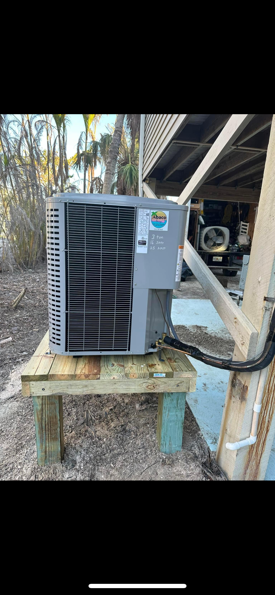 A broken air conditioner is sitting on top of a wooden table.