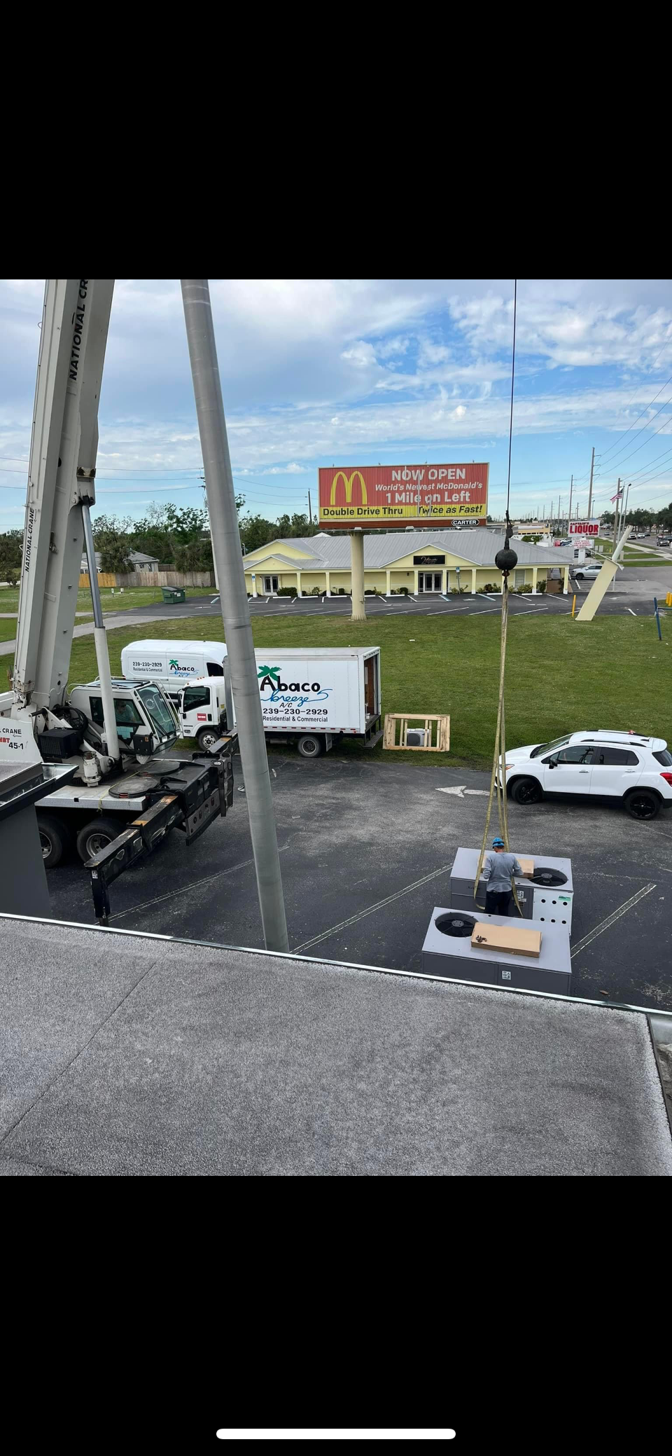 A ferris wheel is being built in a parking lot.
