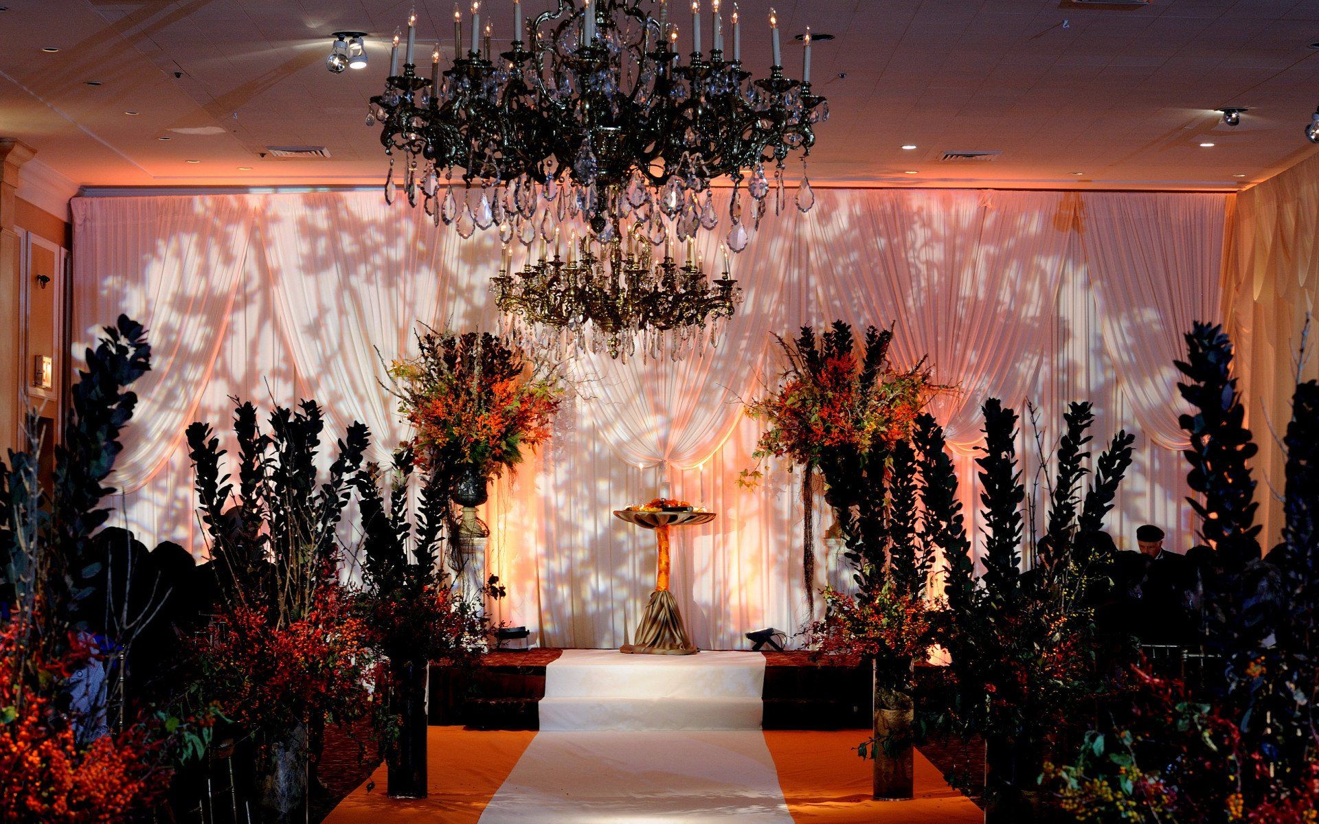 A stage with a chandelier and flowers on it