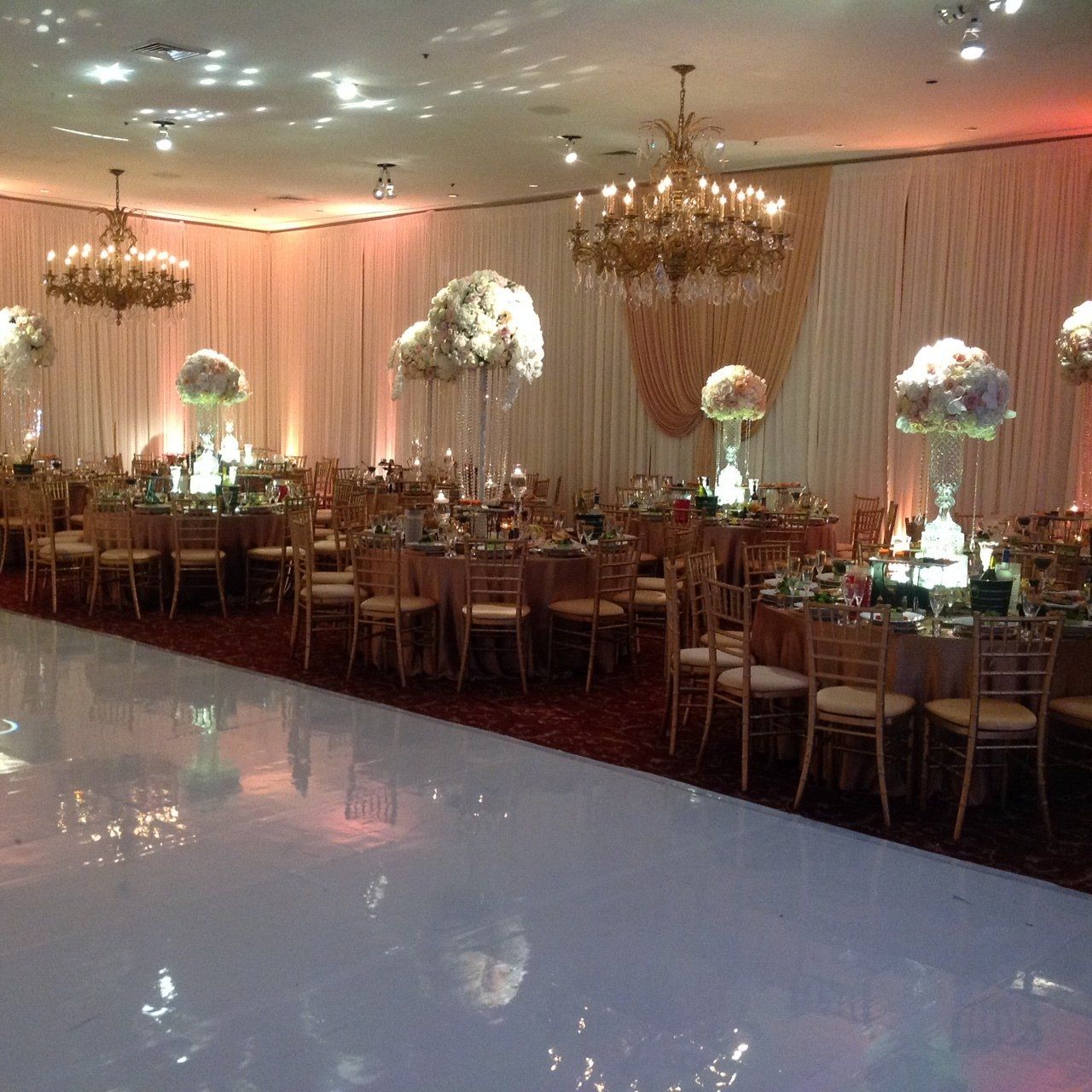 A large room filled with tables and chairs and a dance floor.