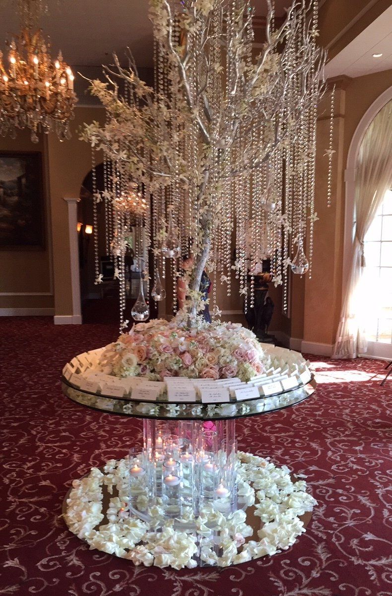A table decorated with flowers and crystals in a room with a chandelier.