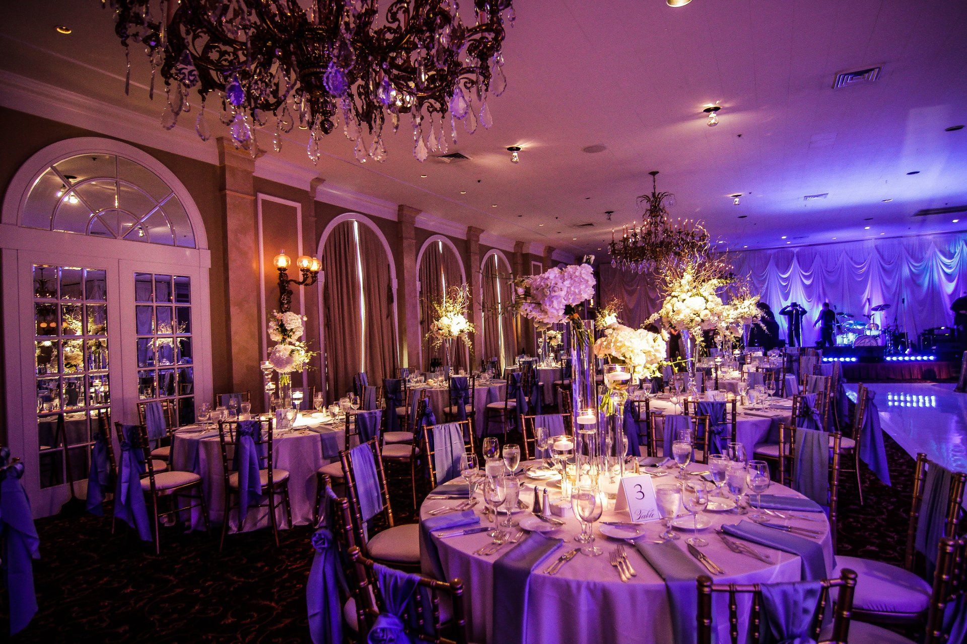 A large room with tables and chairs set up for a wedding reception.