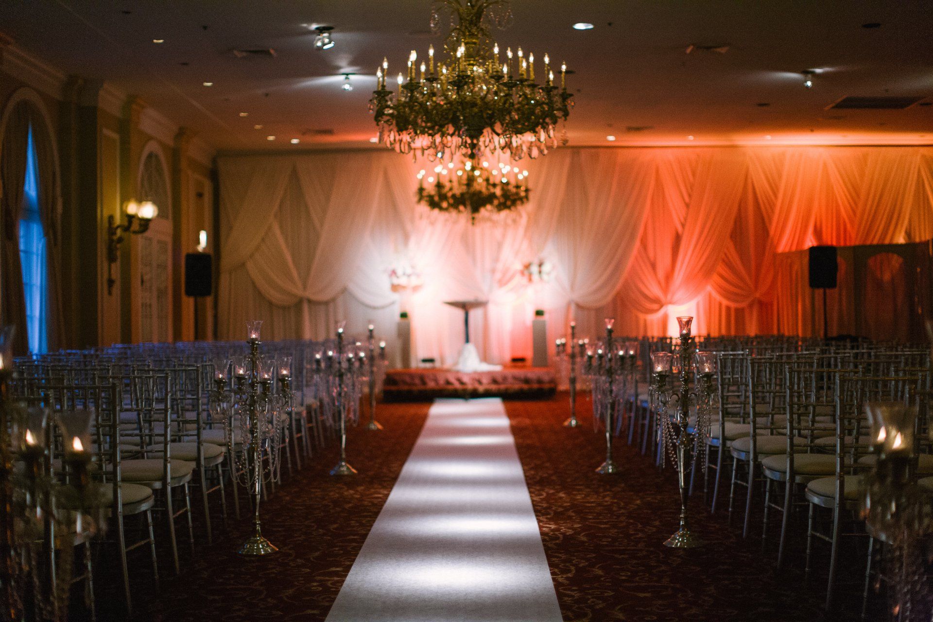 A large room with rows of chairs and a chandelier.