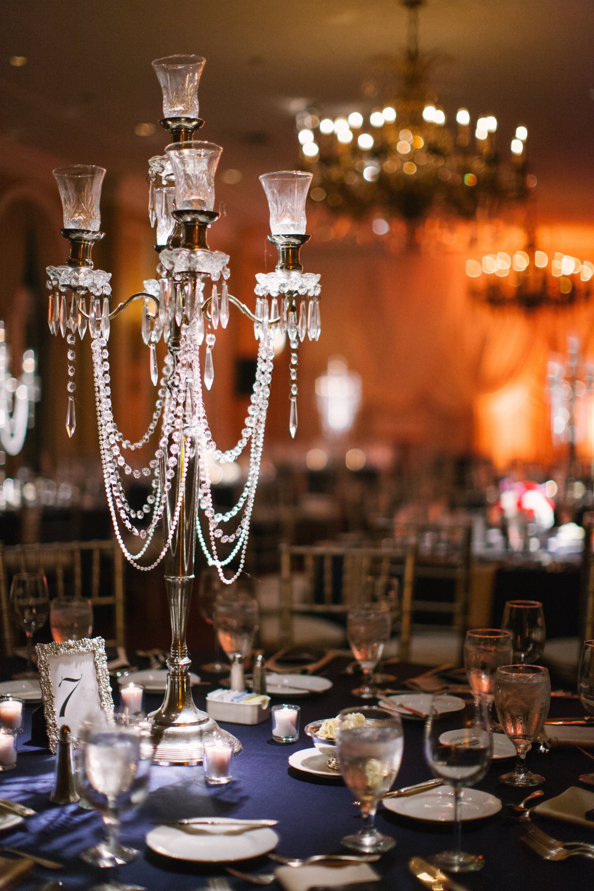 A candelabra is sitting on top of a table with plates and glasses.