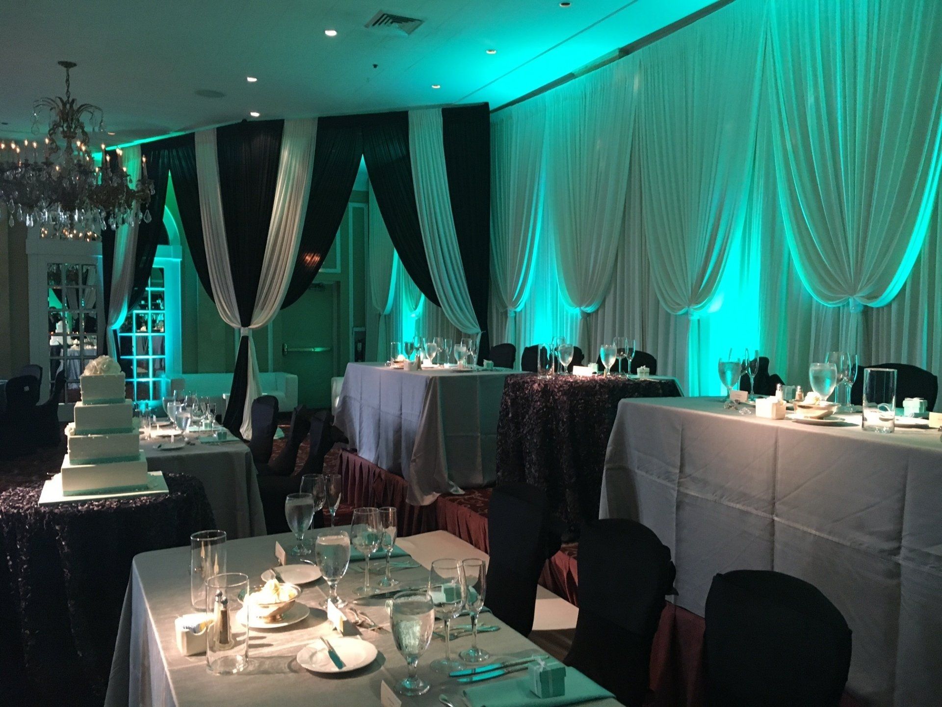 A large room with tables and chairs set up for a wedding reception