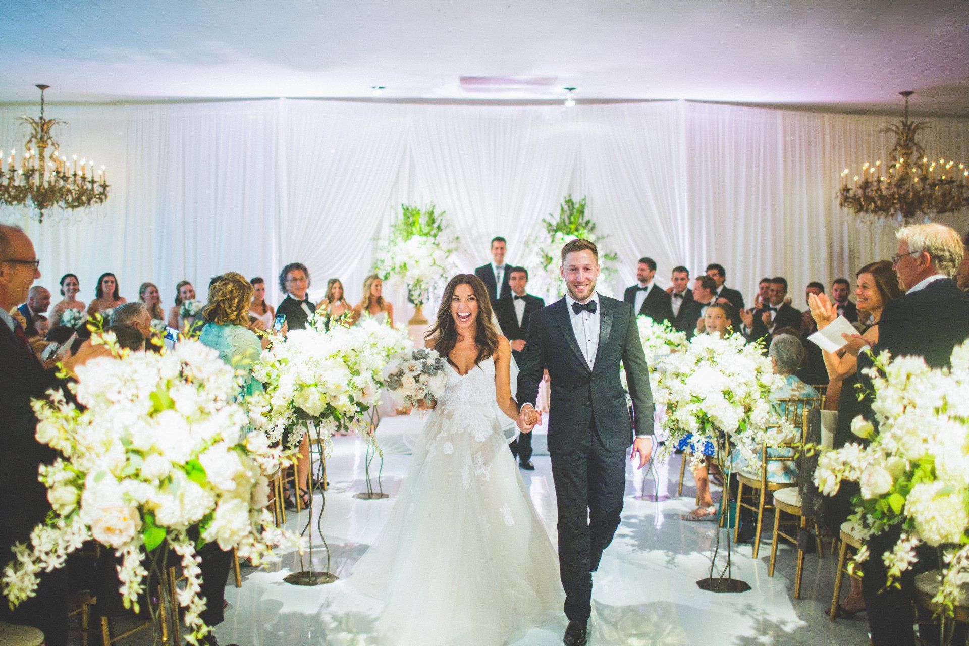 A bride and groom are walking down the aisle at their wedding.