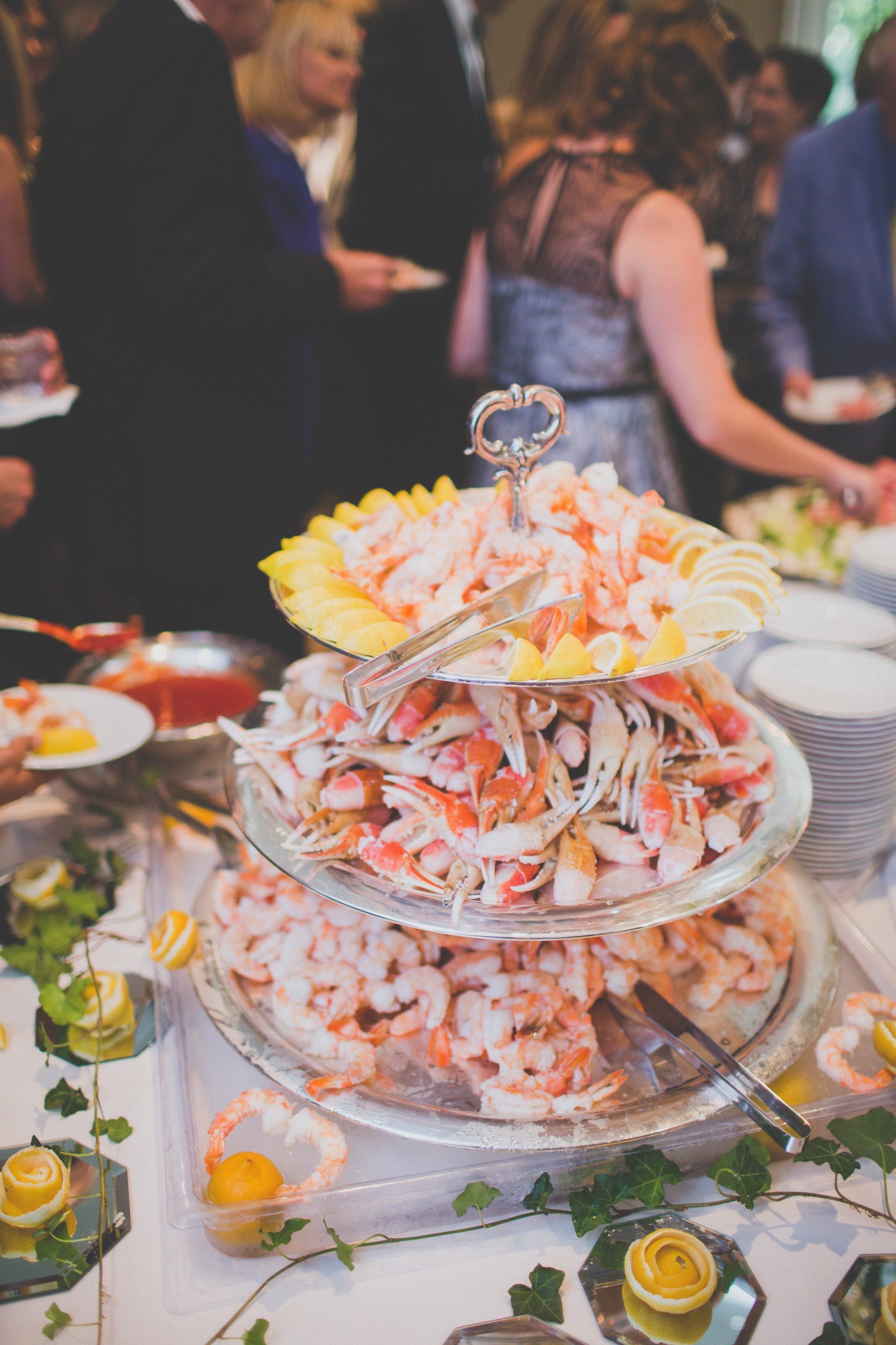 A buffet table with a stack of shrimp on top of it.