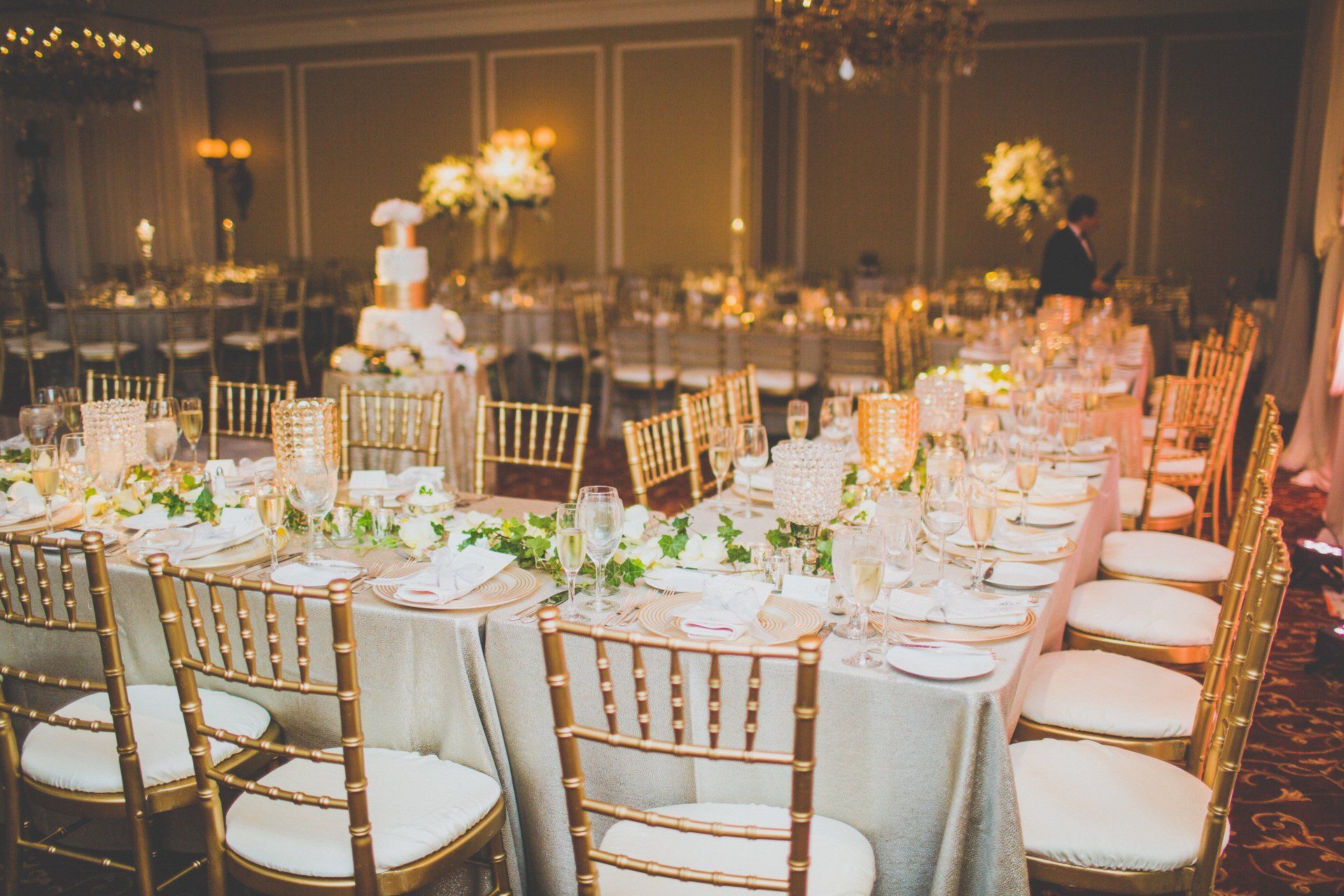 A long table with a cake on top of it is set for a wedding reception.