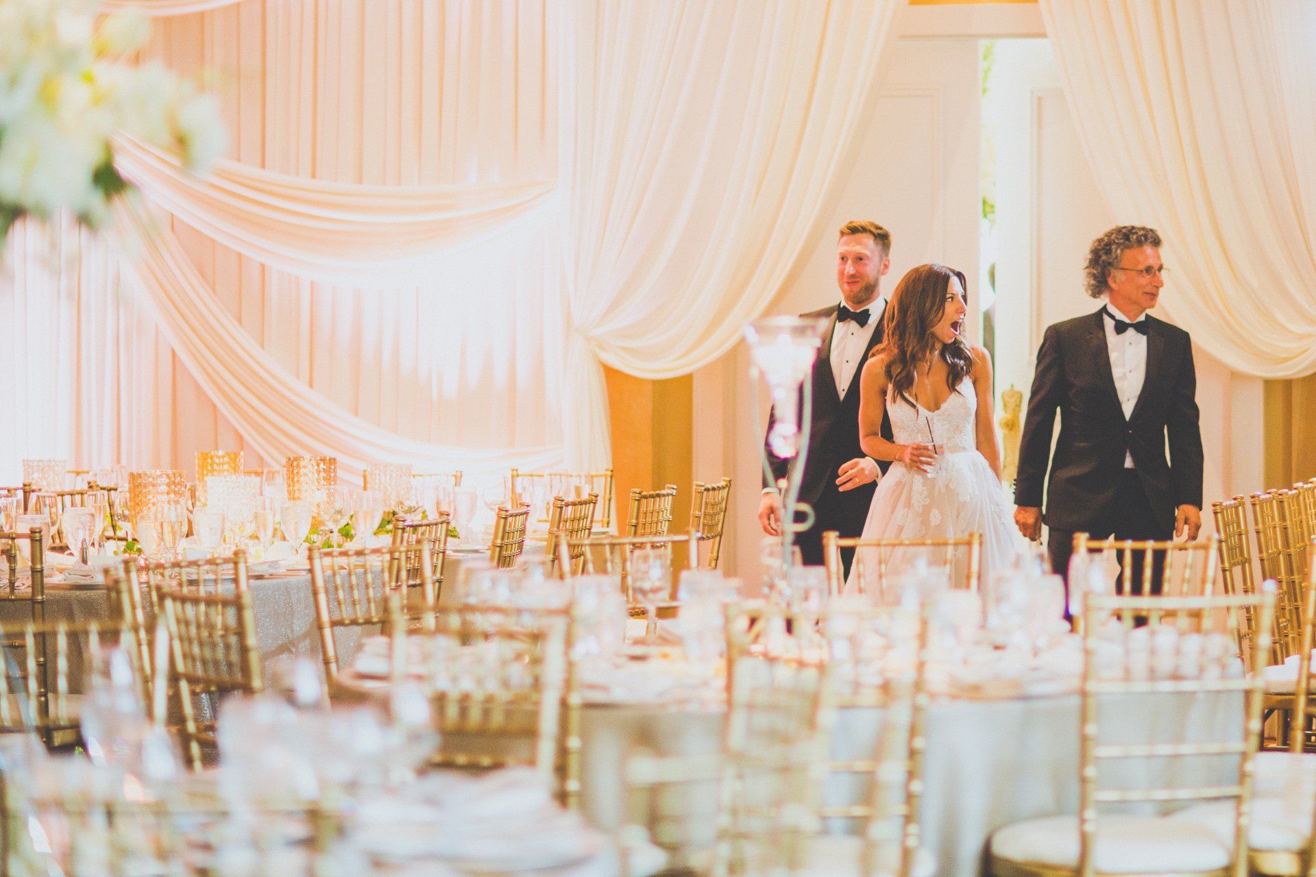 A bride and groom are walking through a wedding reception.