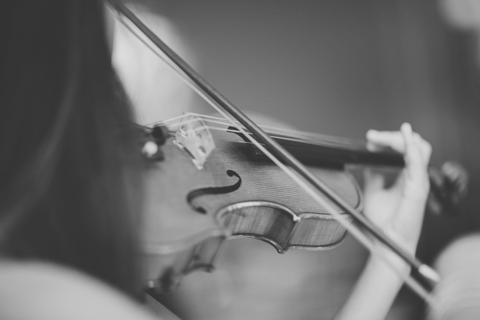 A woman is playing a violin in a black and white photo.