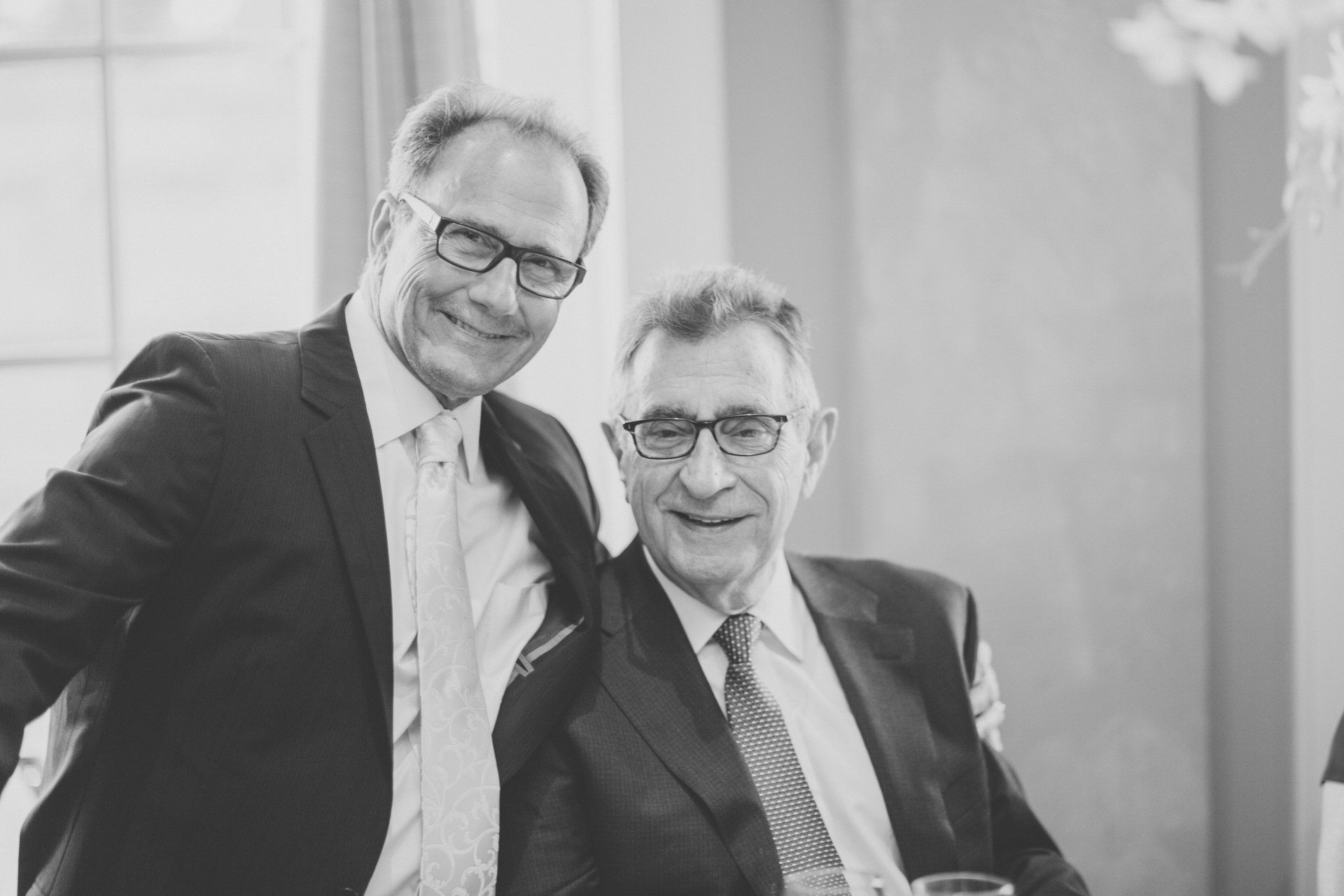 Two men in suits and ties are posing for a picture together.
