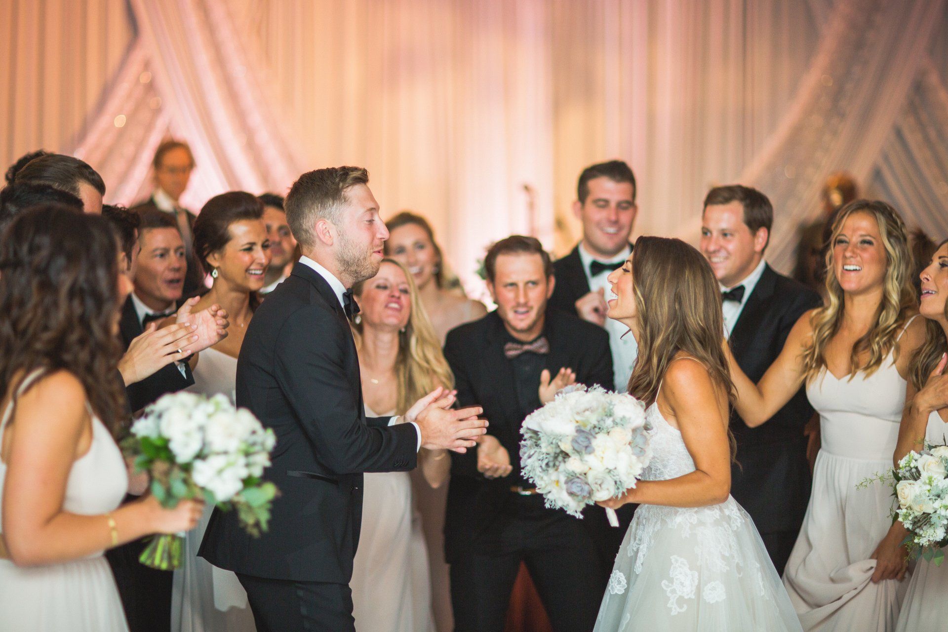 A bride and groom are dancing with their wedding party at their wedding reception.